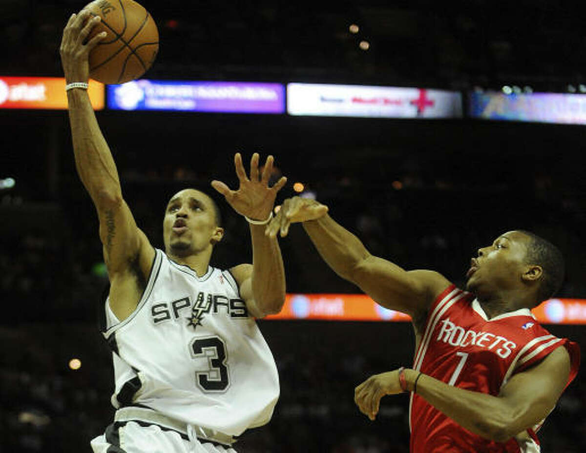 Spurs George Hill shoots a layup as Rockets guard Kyle Lowry defends.
