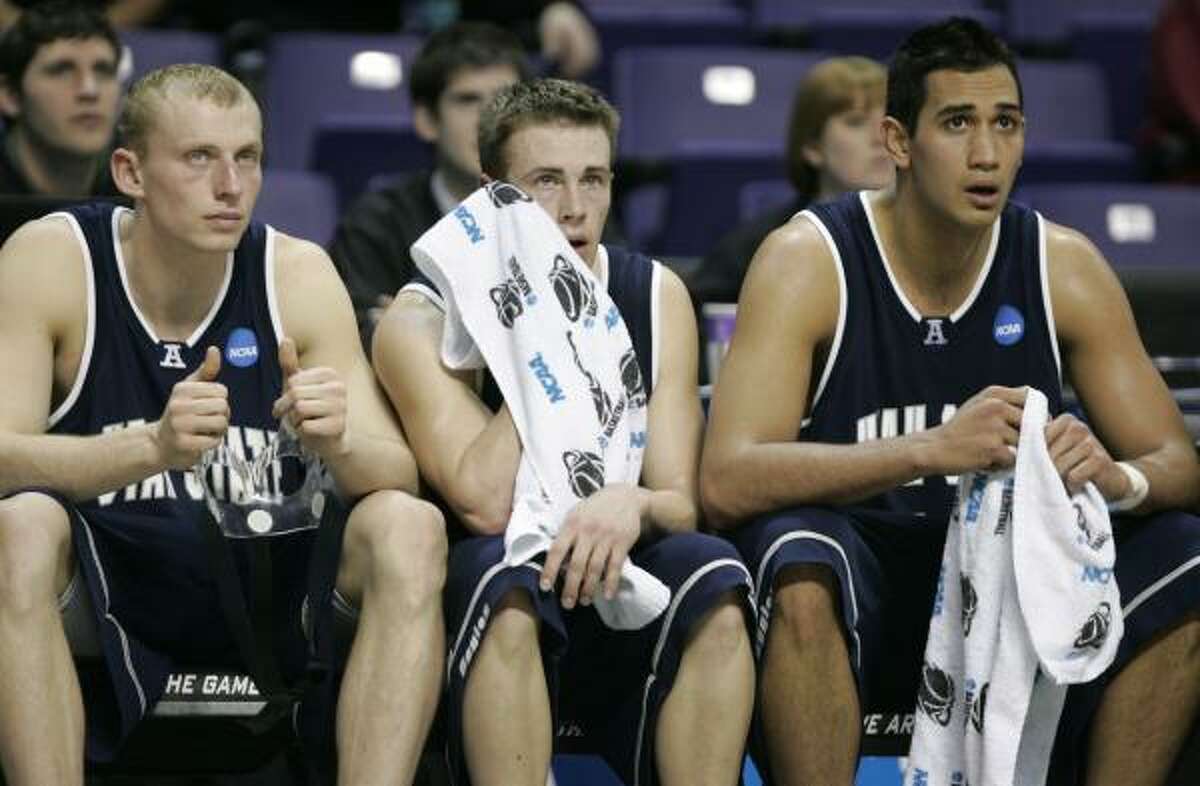 Utah State's Brady Jardine, left, Jared Quayle, center, and Tai Wesley sit on the bench near the end of the game.