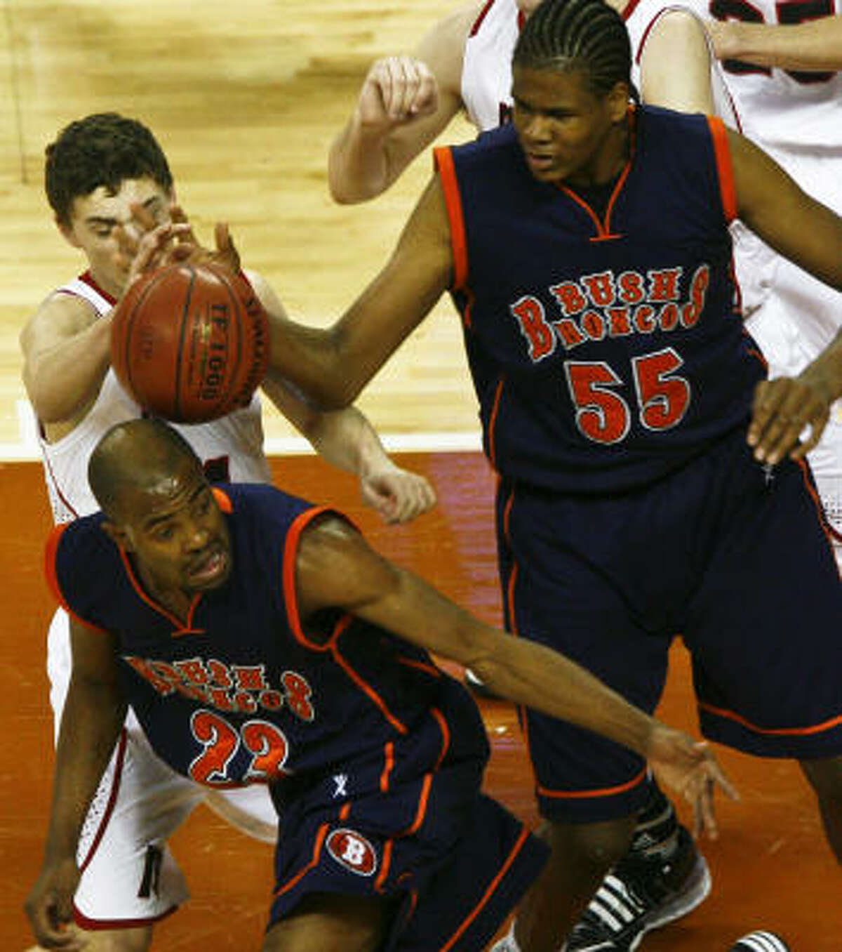 Bush's Cameron Ridley (55) and Marcus' Cory Needs, center, try to grab a loose ball as Jordan Clark gets out of the way.