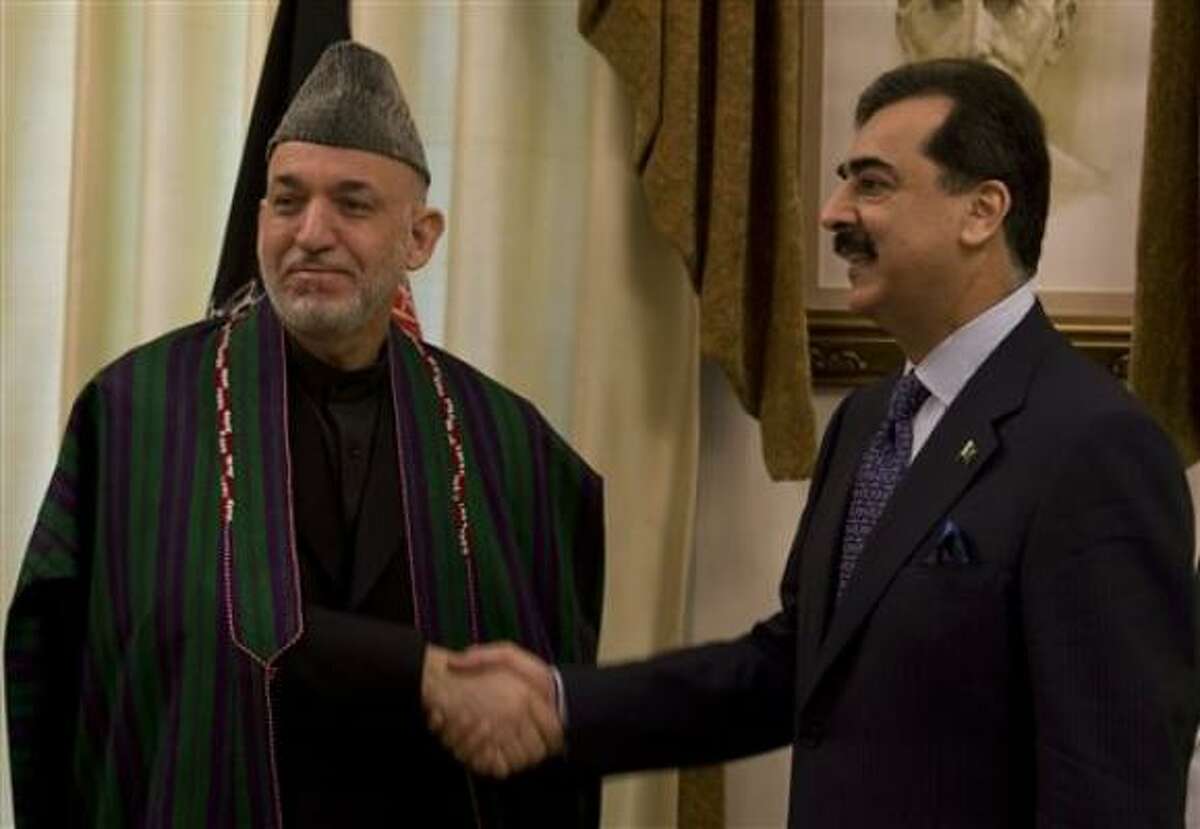 El presidente afgano Hamid Karzai, izquierda, saluda al primer ministro paquistaní Yousuf Raza Gilani en la residente del segundo, en Islamabad, Pakistán, el jueves 11 de marzo del 2010.