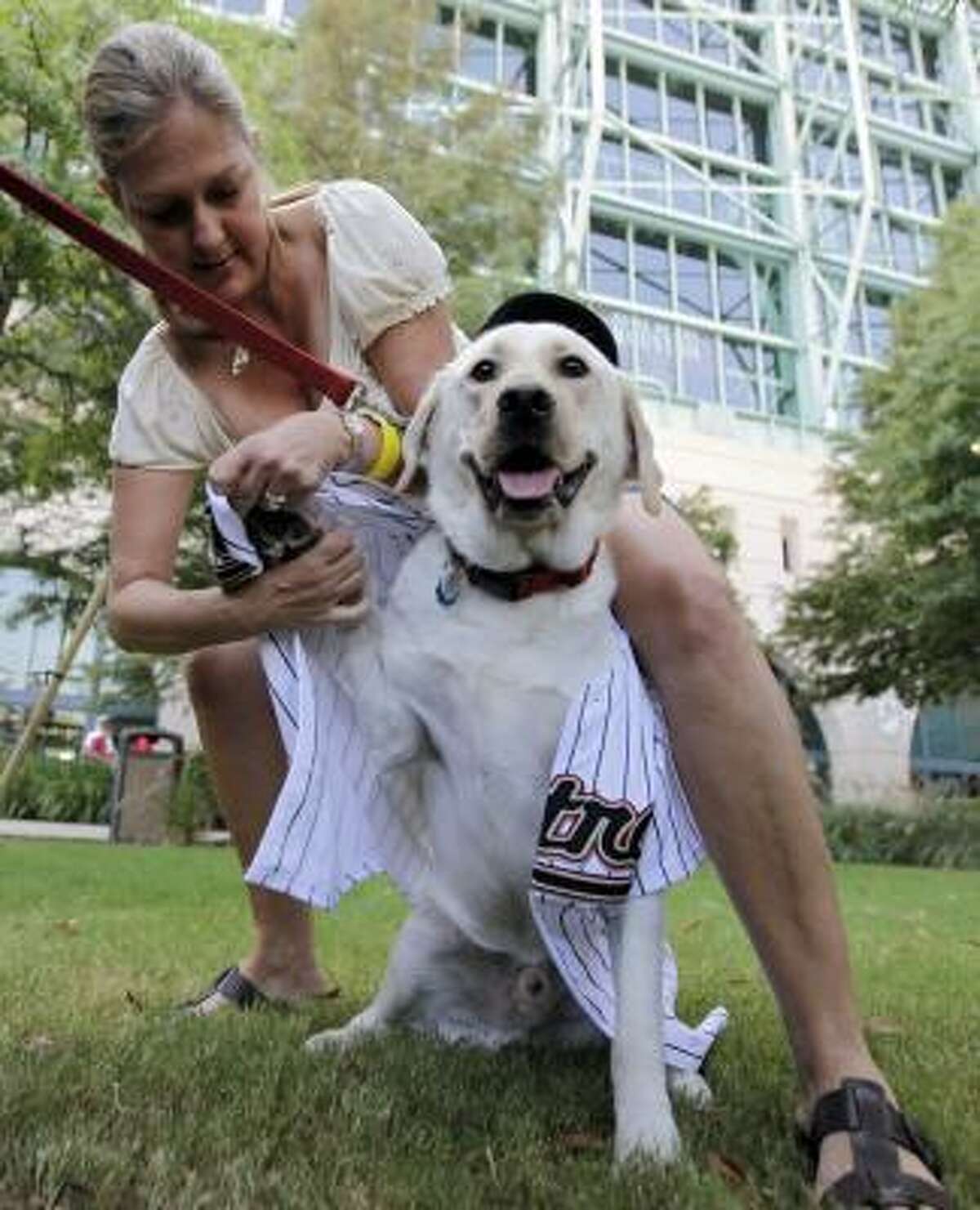 Jan Cohen puts a Houston Astros "Barkman" jersey on her dog Captain outside Minute Maid Park before the start of the Astros and Philadelphia Phillies baseball game.