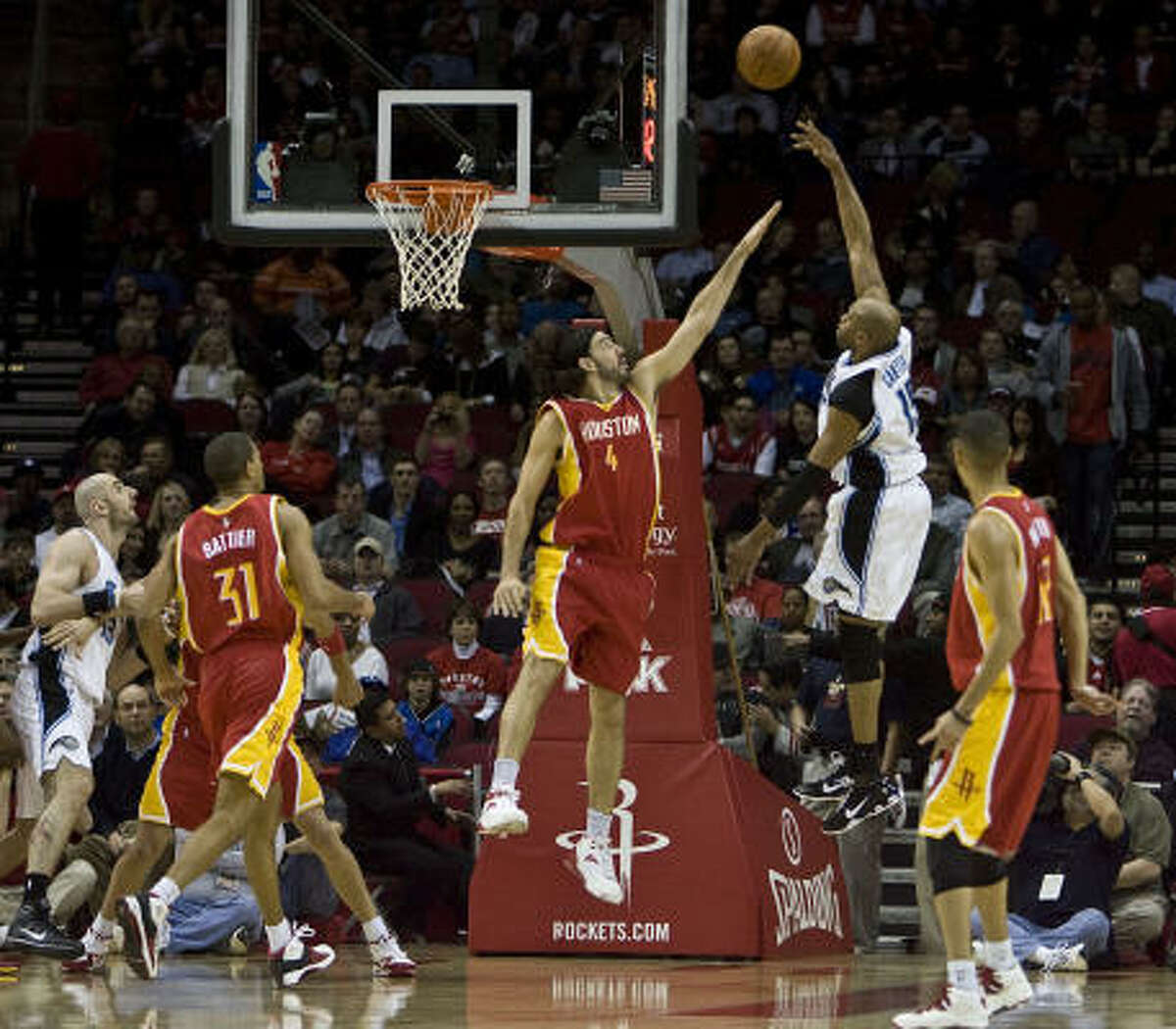 Orlando's Vince Carter, second from right, shoots over Rockets forward Luis Scola during Wednesday's game at the Toyota Center.