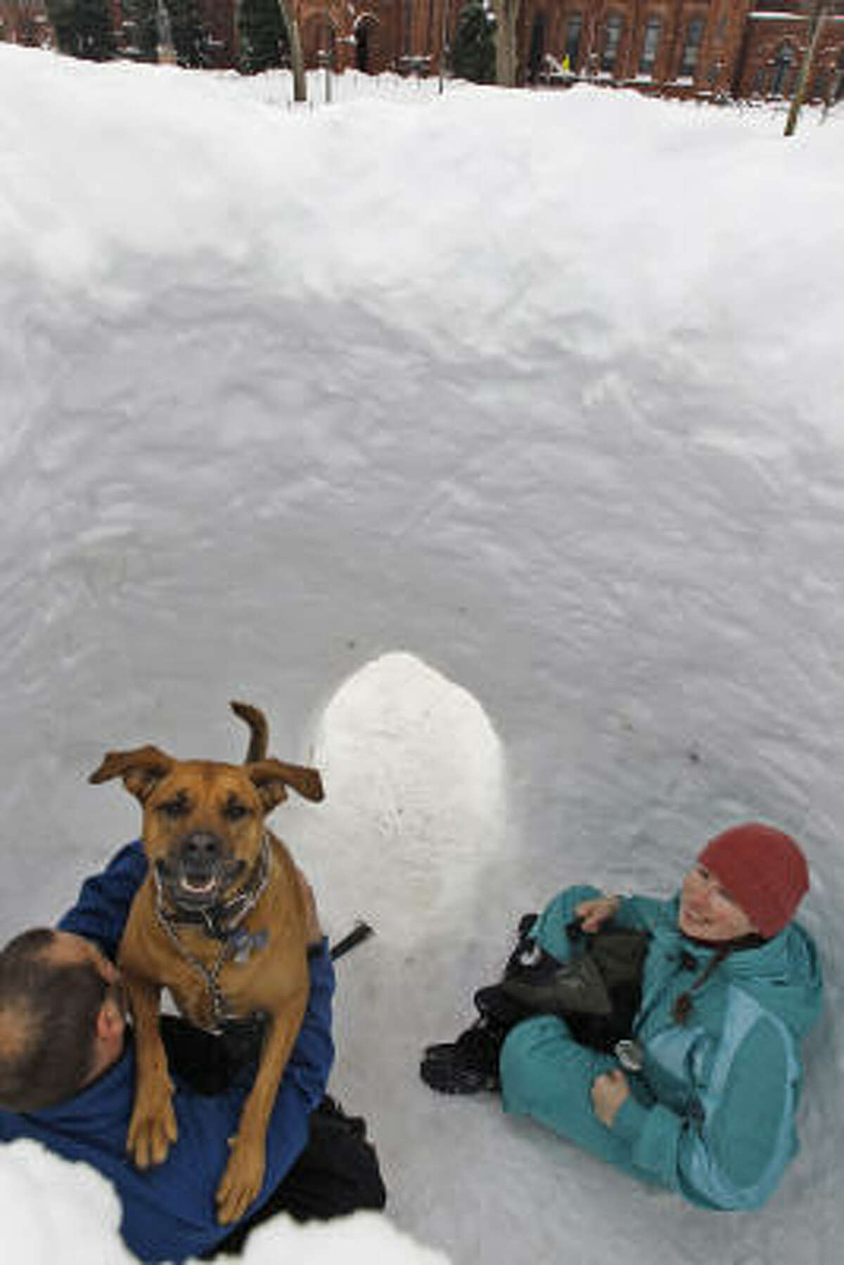 Stuart Naranch plays with his dog, Brunne, as his wife Sarah Naranch looks on inside a snow fort on the National Mall in Washington Feb. 9. Share your dog pics.