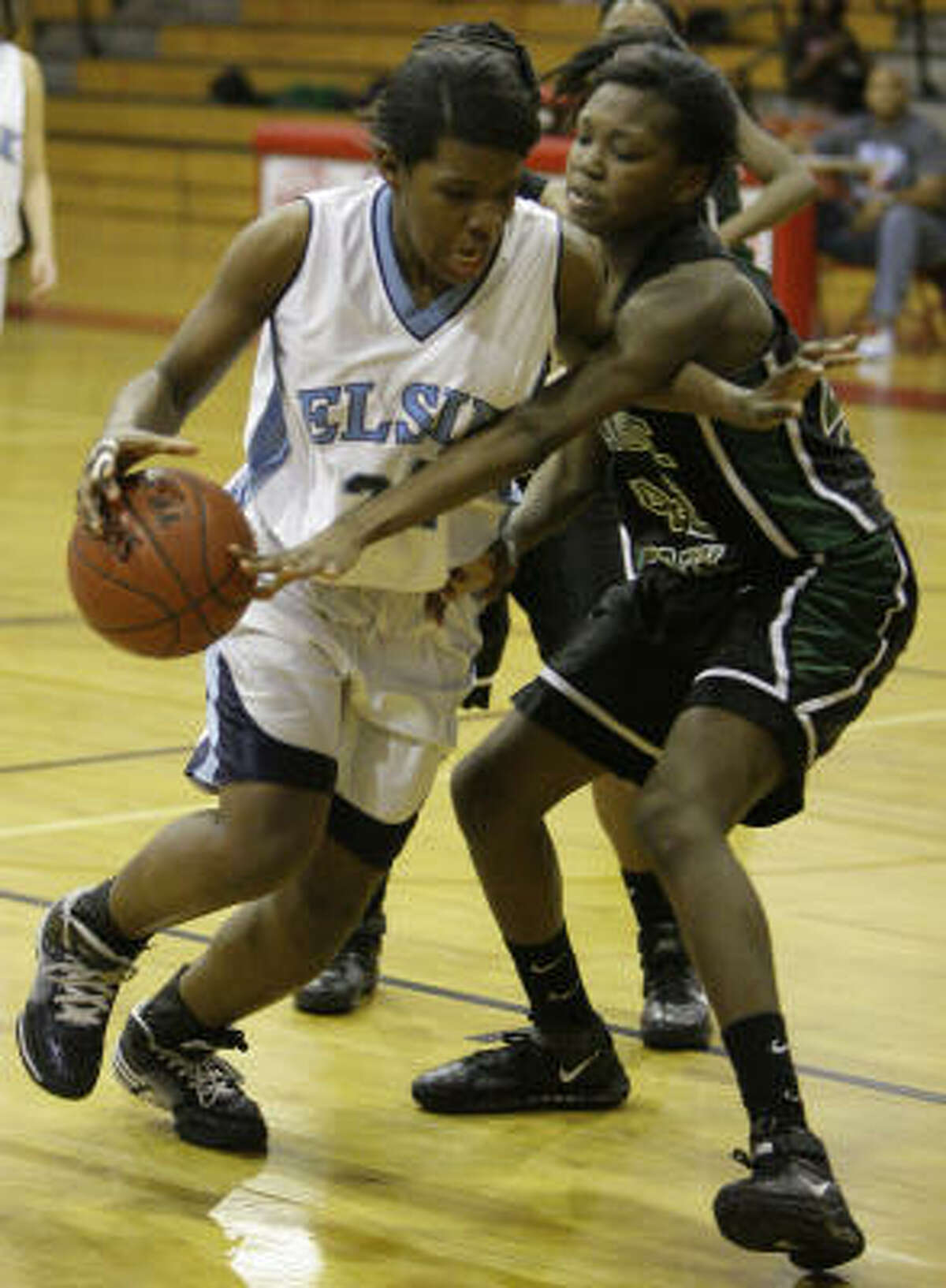 Elsik's Crystal Porter, left, takes the ball around Mayde Creek's Dominique Taylor.