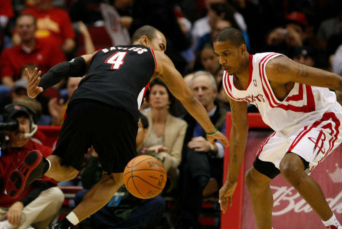Trail Blazers guard Jerryd Bayless (4) loses the ball to Rockets forward Trevor Ariza in the third quarter.