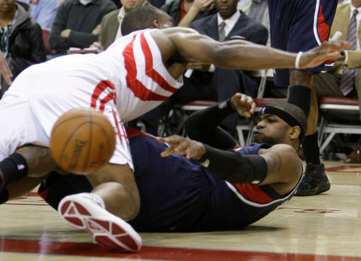 Atlanta's Josh Smith is still able to get off a pass from the ground under pressure from Carl Landry.