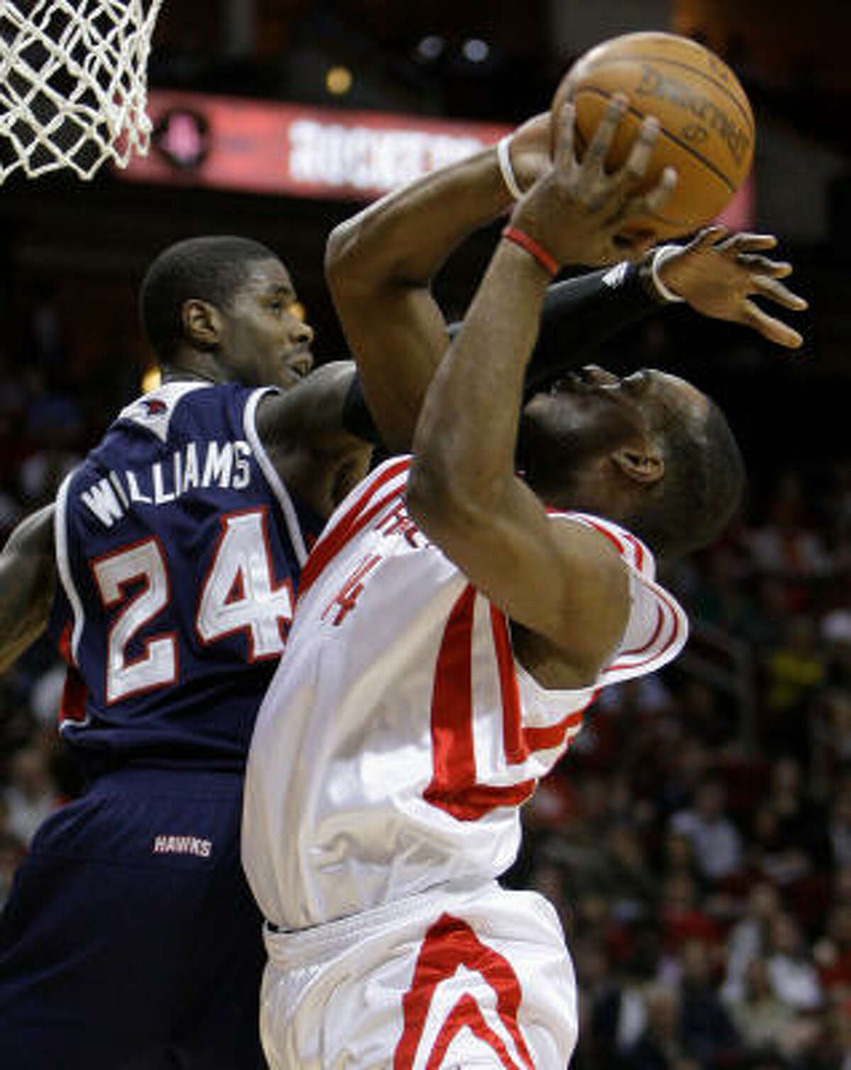 Rockets forward Carl Landry is fouled by Atlanta's Marvin Williams on a shot.