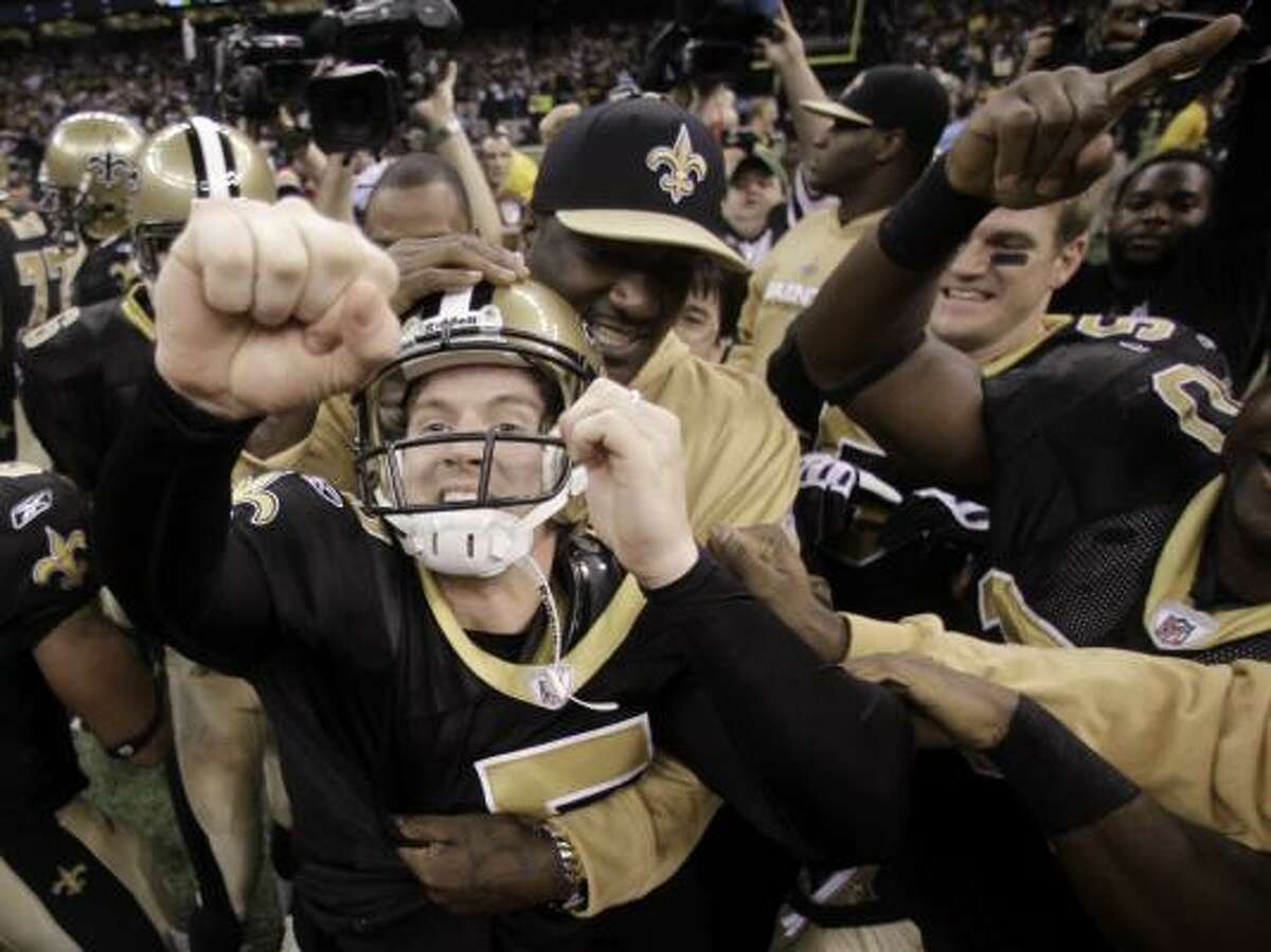 Saints kicker Garrett Hartley (5) celebrates with his teammates after kicking the winning field goal during overtime.