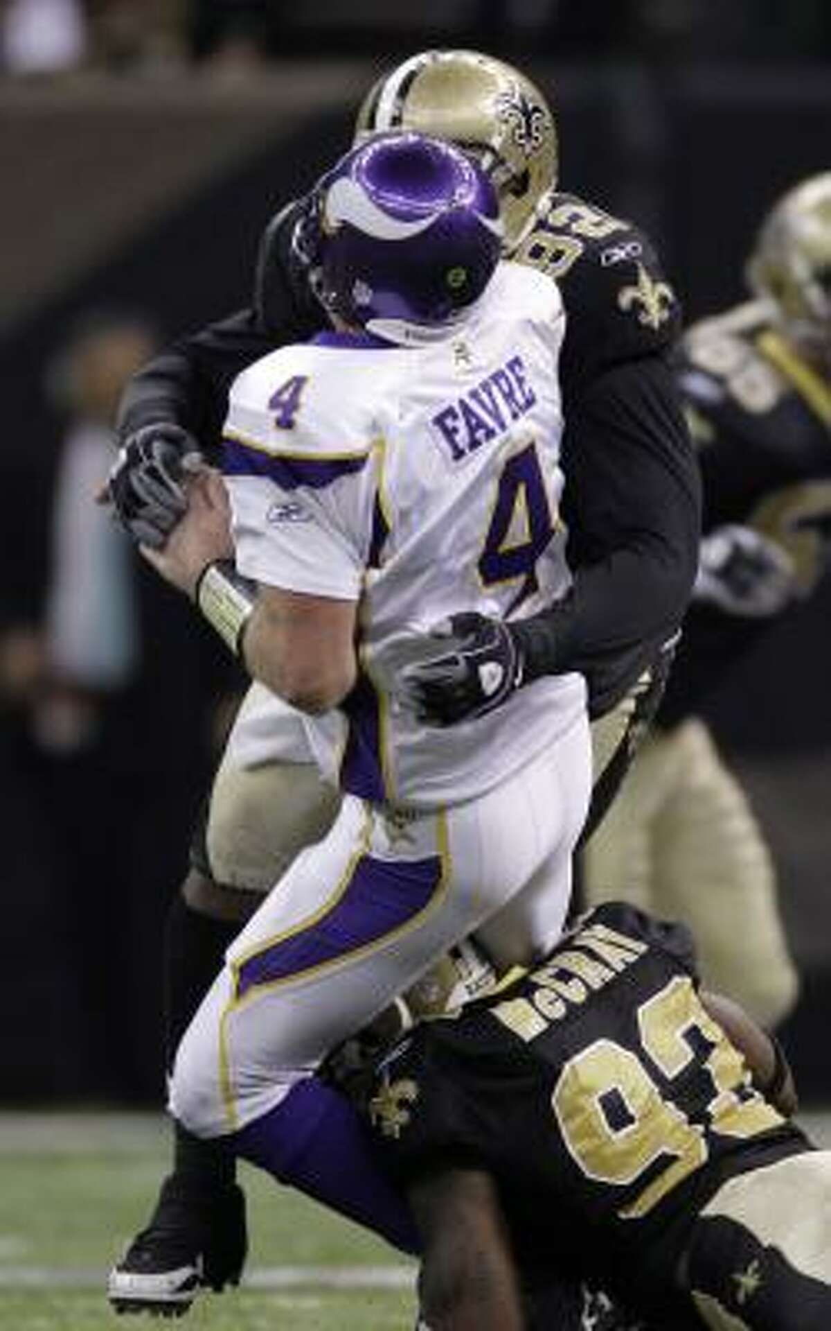 Vikings quarterback Brett Favre is taken down by Saints defensive linemen Remi Ayodele (92) and Bobby McCray during the fourth quarter.