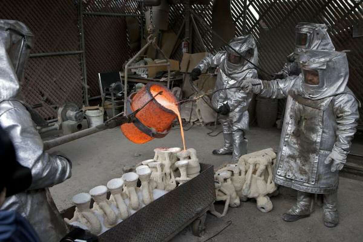 Workmen pour molten bronze metal into cast molds for the Screen Actors Guild Award's "The Actor" statuettes.