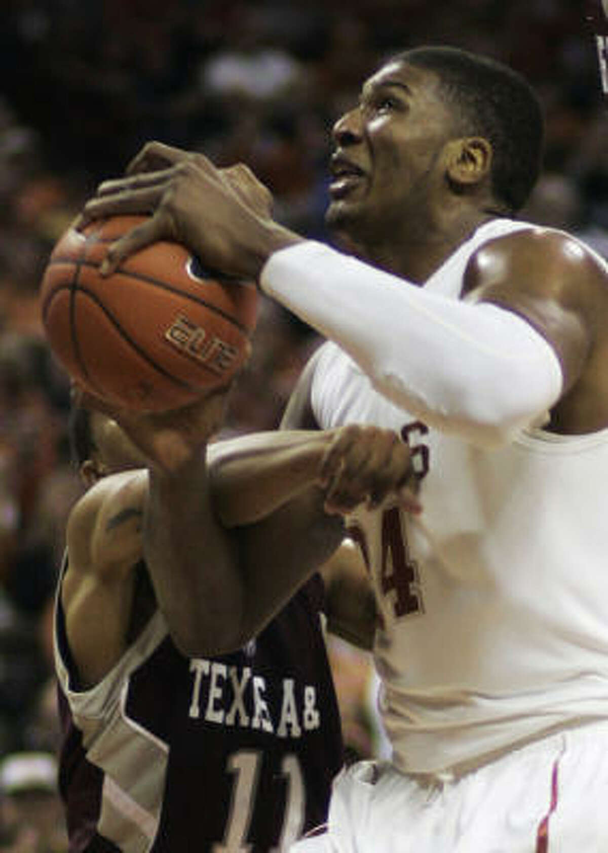 Texas center Dexter Pittman is fouled by Texas A&M guard B.J. Holmes during the first half.