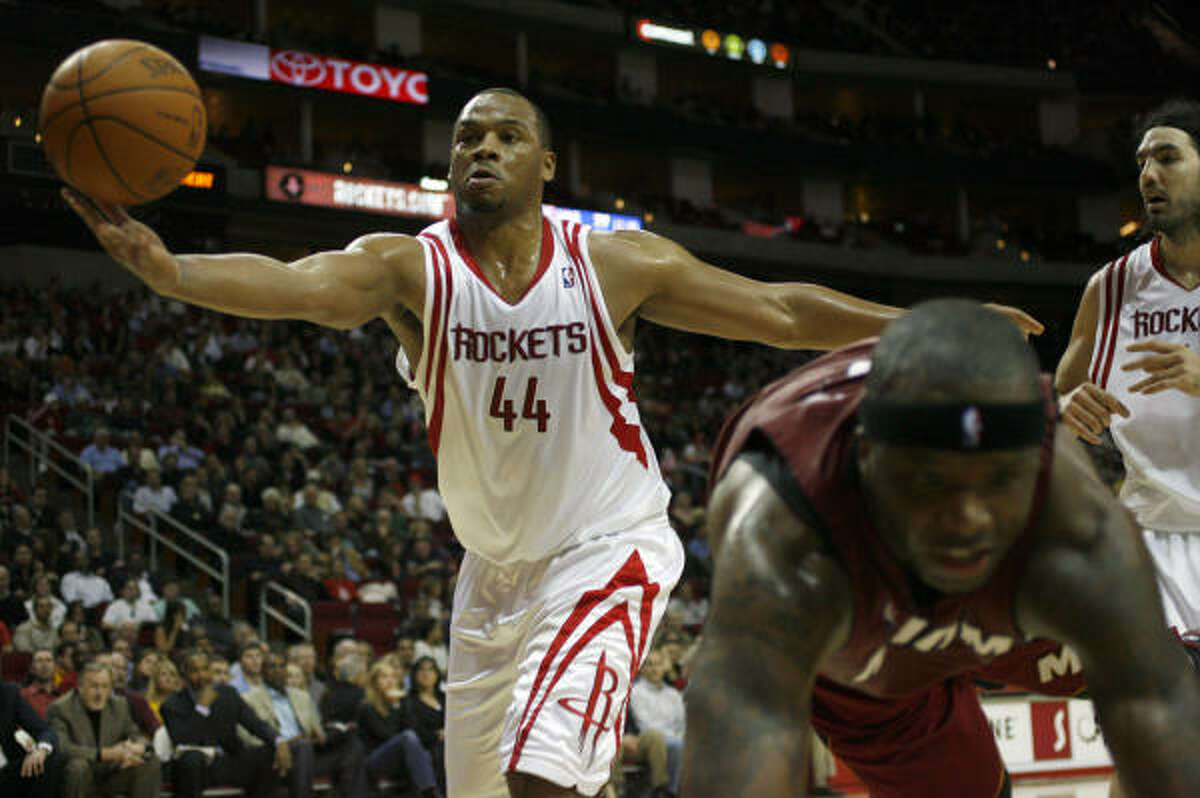 Houston's Chuck Hayes (44) attempts to save the ball as Miami's Jermaine O'Neal hits the floor in the fourth quarter.