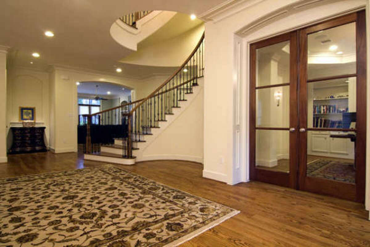 Grand entry with sprial staircase and high ceilings. Sunken wine room behind staircase.