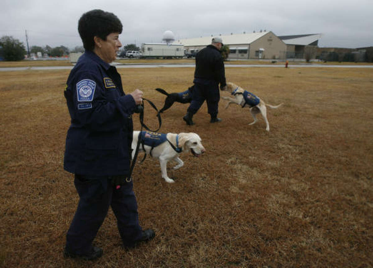 Shelley Swedlaw, a K-9 search specialist with Texas Task Force One, walks Scout during a break as members await a plane to head to Haiti to help in the quake relief efforts.