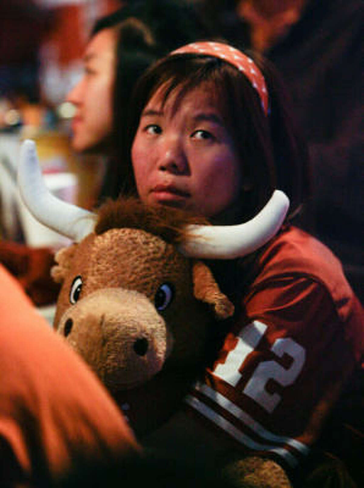 With Texas quarterback Colt McCoy out of the game, Vienna Lei sits upset while watching Thursday night's BCS title game between Texas and Alabama at a Texas Ex watch party at Lucky's Pub in Houston.