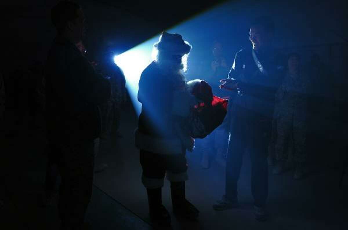 A US soldier dressed up as Santa Claus distributes gifts to the US soldiers during a concert to celebrate Christmas at Bagram Air Base, some 50 kms north of Kabul on Christmas Eve. There will be no Christmas turkey and trimmings for US marines at Patrol Base Talibjan this year -- a chemically heated meal of preserved meat is all the infantry men expect. The troops -- living in unheated tents in the Taliban heartland of Musa Qala district, in southern Afghanistan's Helmand province -- will climb out of their sleeping bags as usual, plan patrols and hope the day ends without casualties.