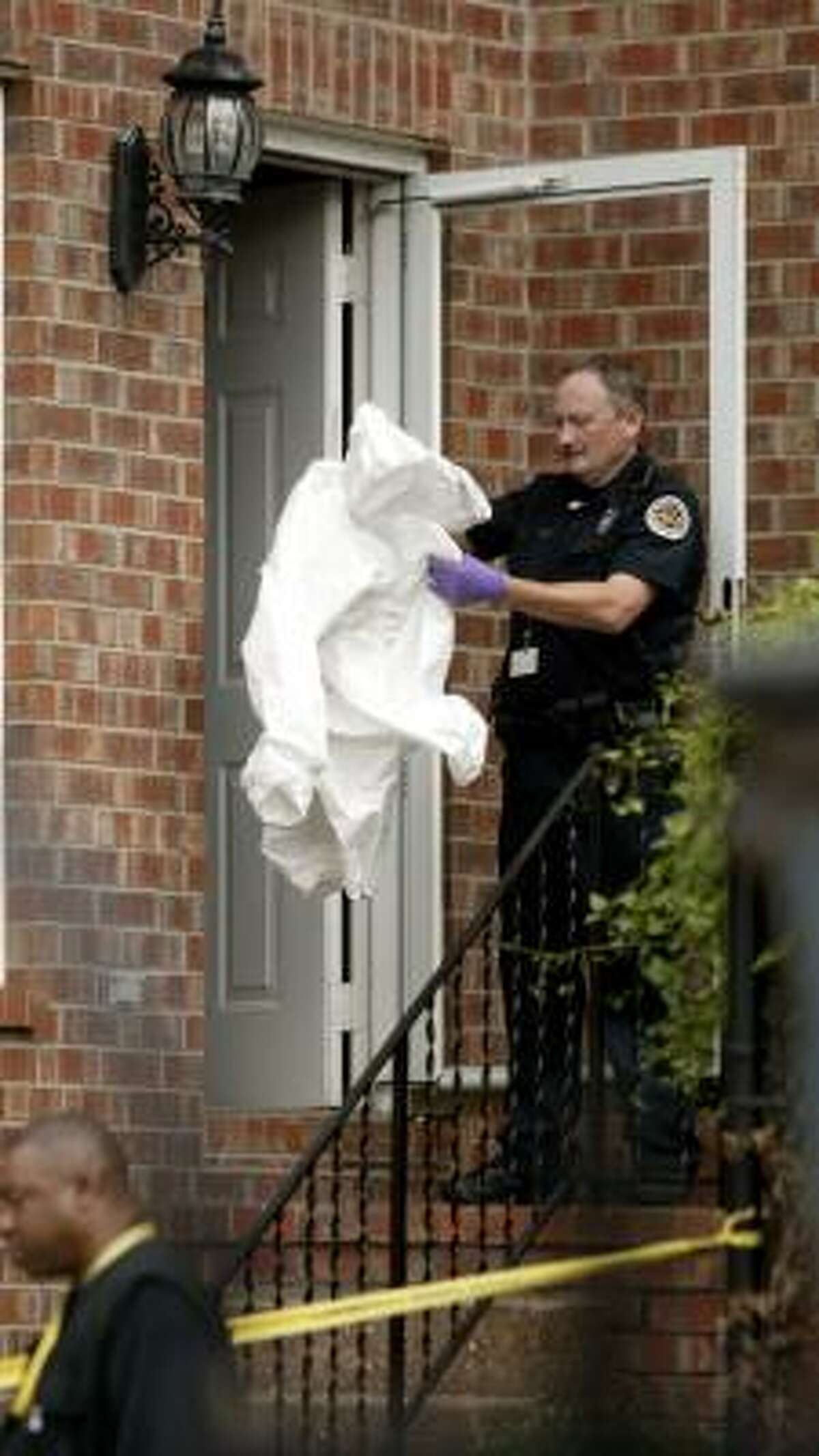 A police officer gets ready to process the Nashville apartment where Steve McNair was shot on Saturday.