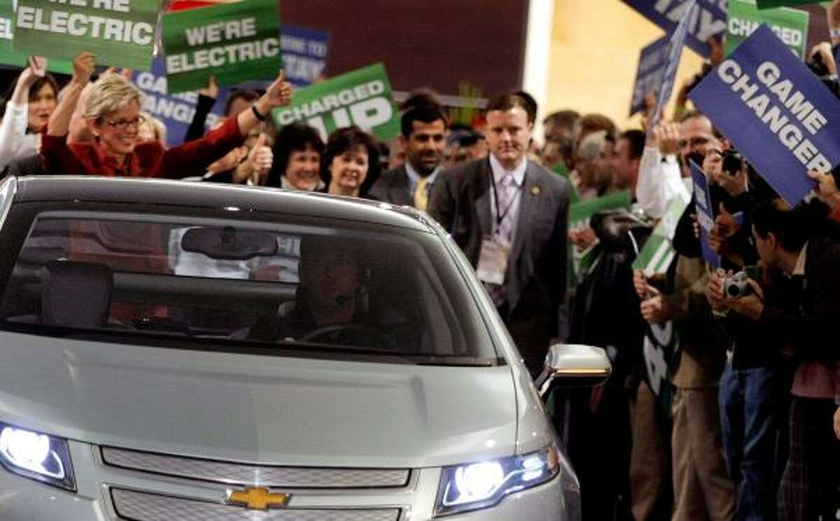 Michigan Gov. Jennifer Granholm, left, marches with auto workers and dignitaries behind a Chevy Volt electric car Sunday at the Detroit International Auto Show.