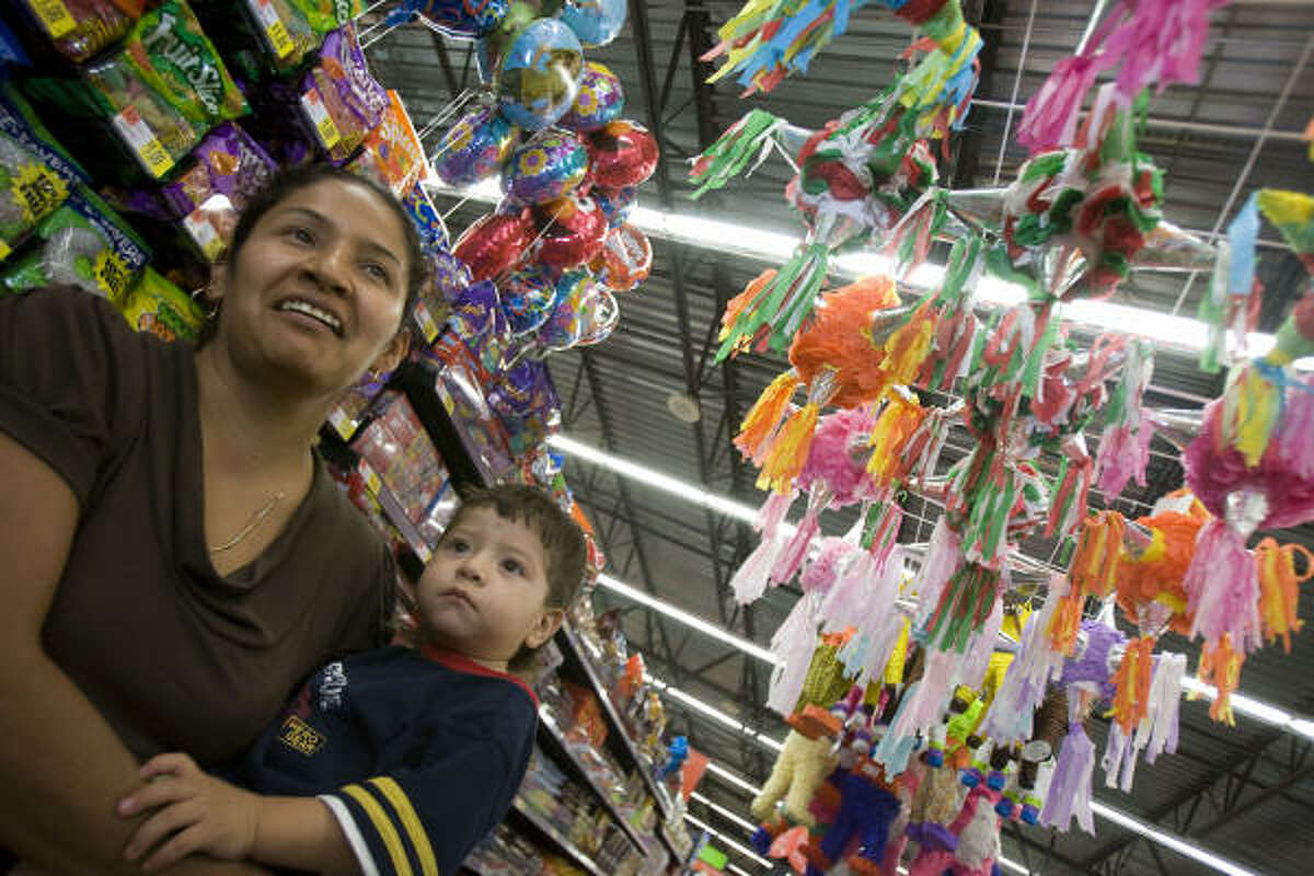 Shopper Rayna Soto and her son Alex Cervantes take in Supermercado de Walmart’s piñata-decorated candy aisle.