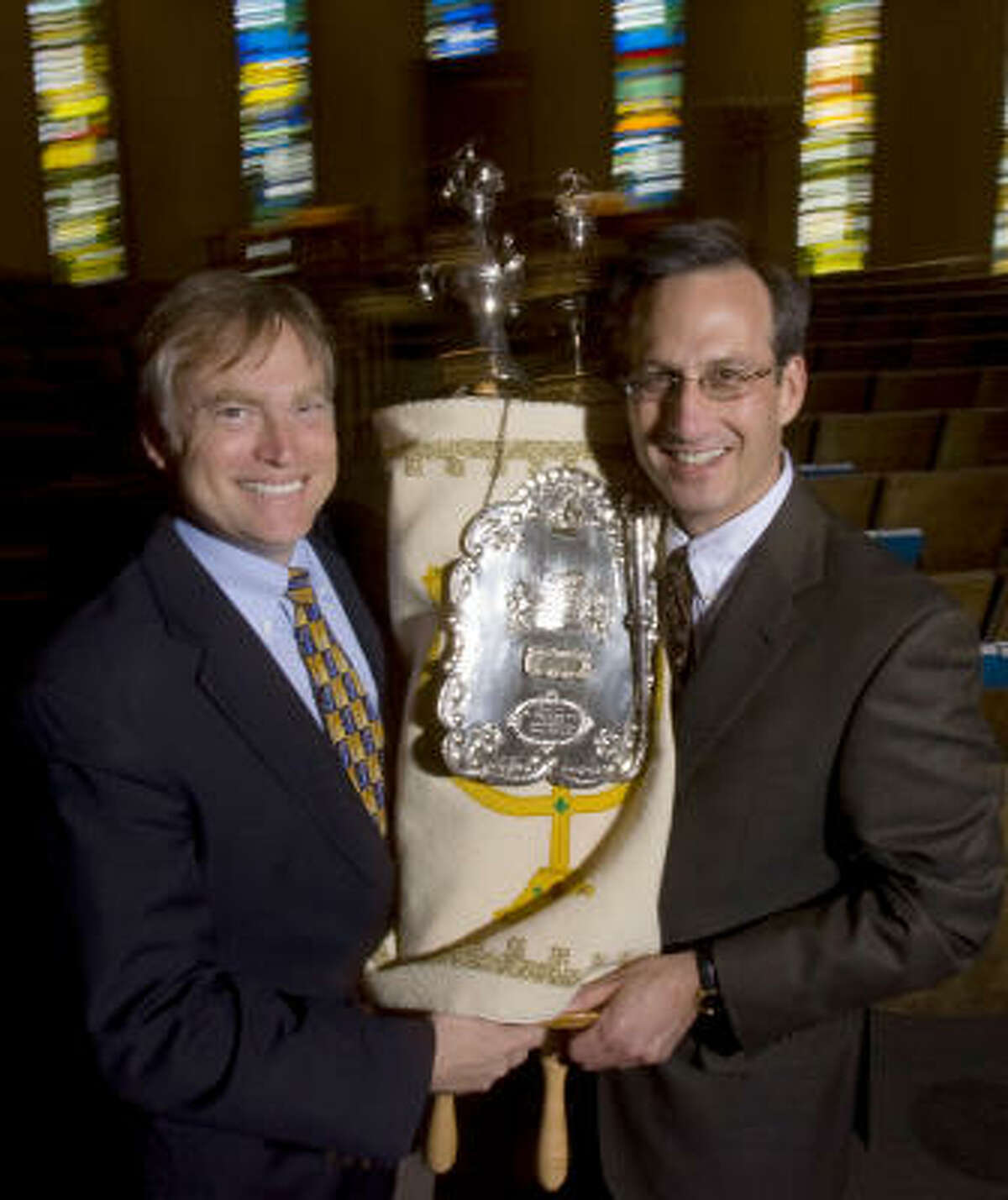 Steven Gross, left, senior rabbi of Houston Congregation for Reform Judaism, and David Lyon, senior rabbi of Congregation Beth Israel, hold a Beth Israel Torah that a member of both congregations paid to have restored and donated to HCRJ.