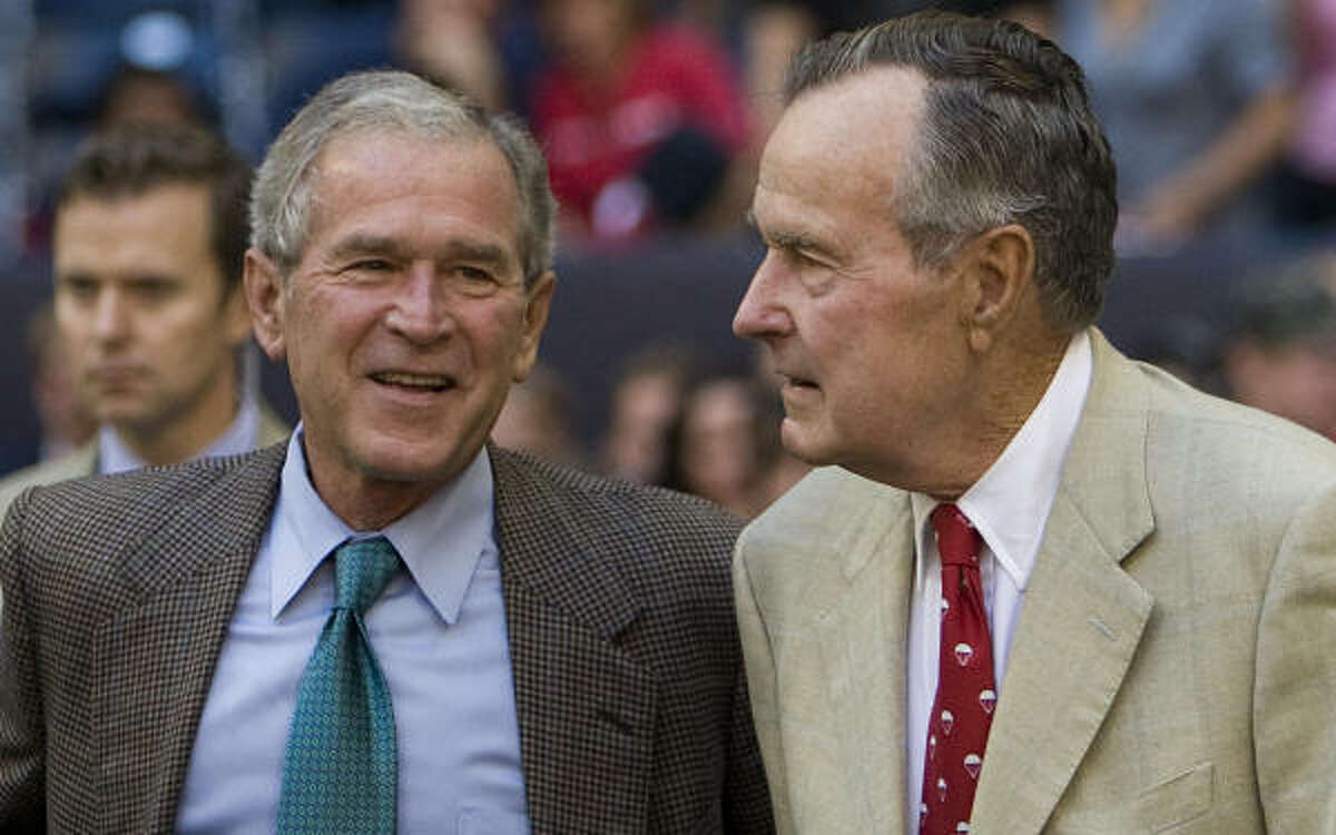 Former presidents George W. Bush, left, and George H.W. Bush watch from the sidelines before Sunday's game.