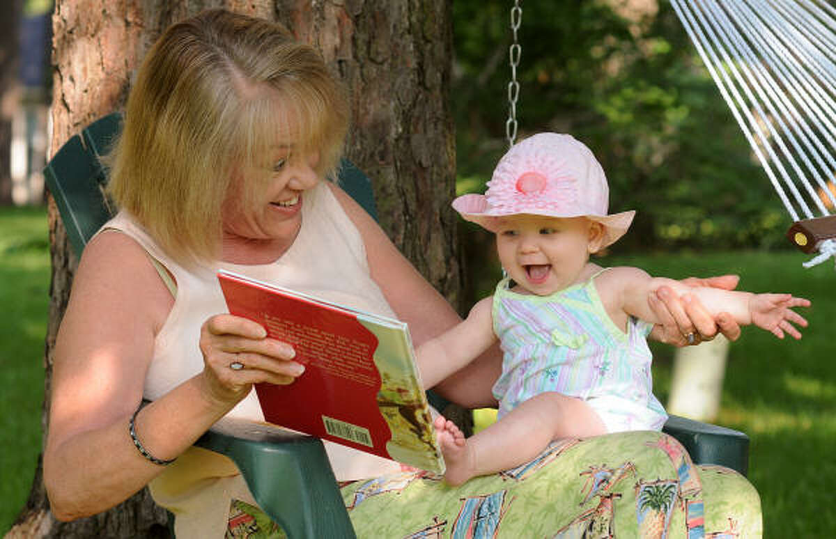 Margaret McManis reads one of the books she has written to her eight month old granddaughter Olivia Scank at McManis' home in River Plantation.