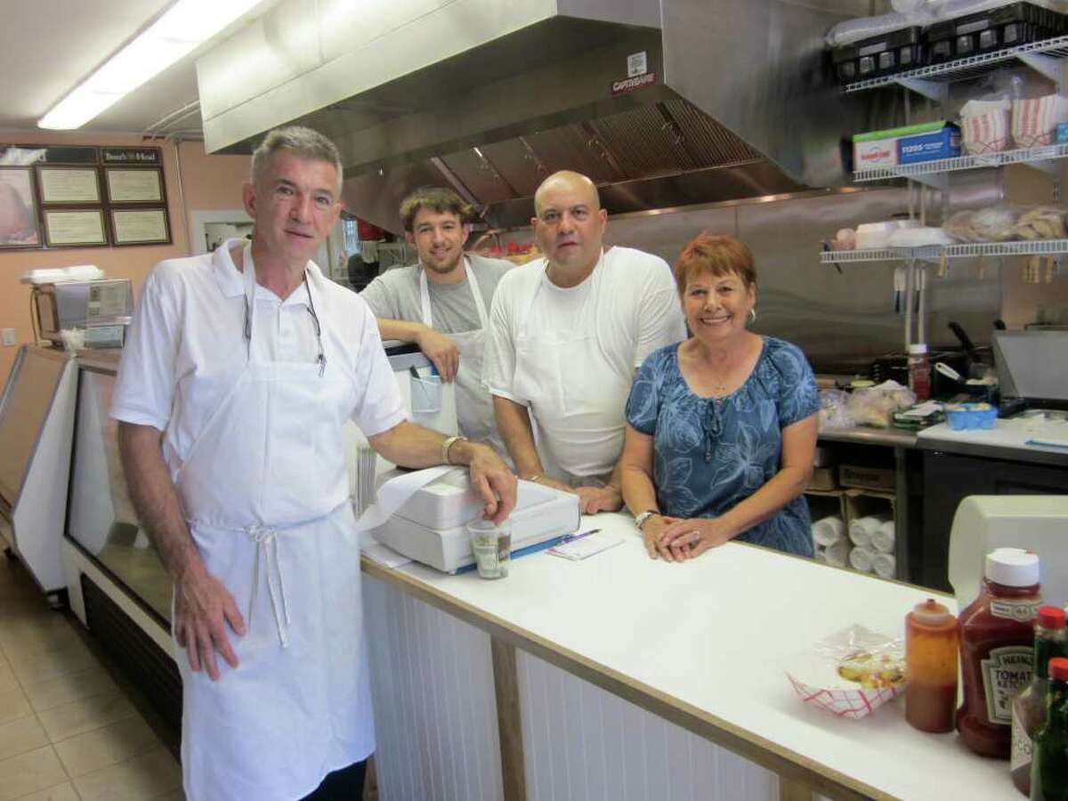 The staff of the White bridge Deli greets their customers with smiling faces. From right to left: owner Michael Duke, his son Andrew, Jose, and Gerry Pittore. - Photo by john H. Palmer