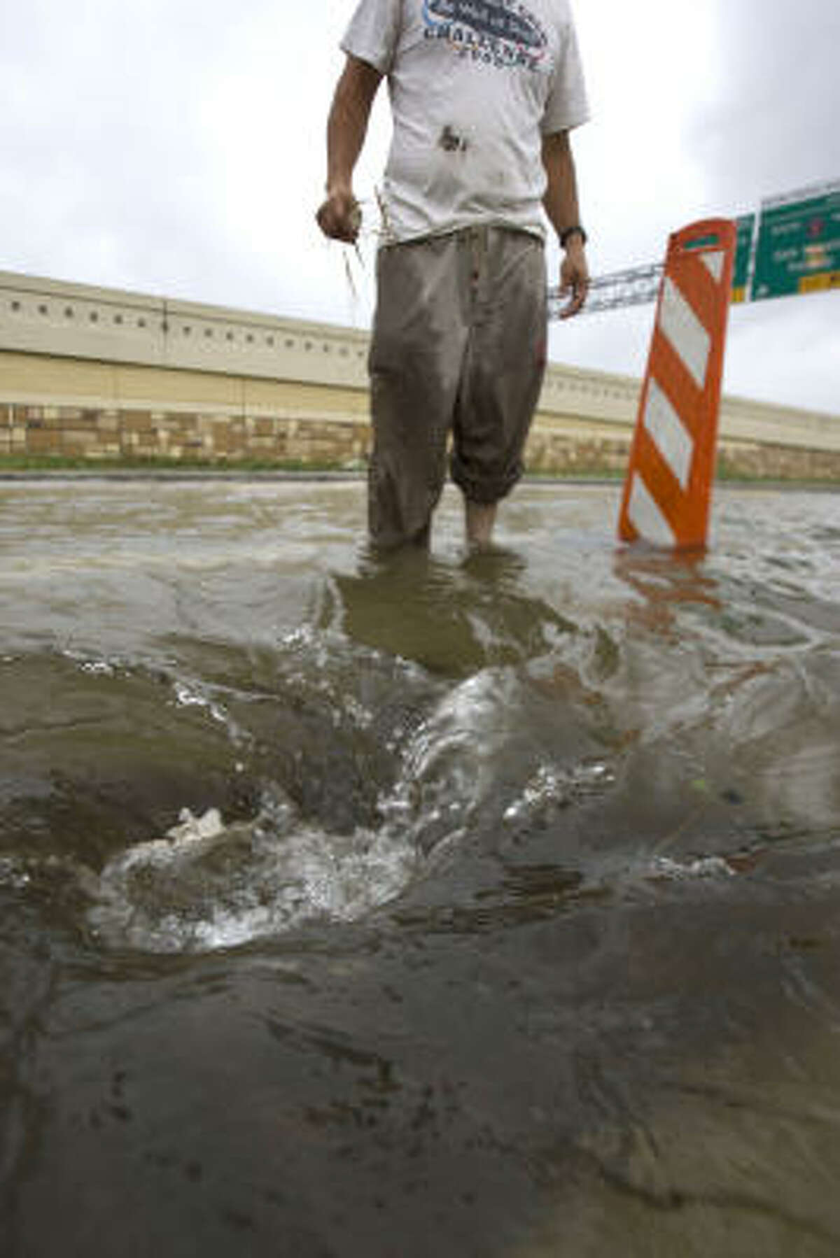 Jose Mendoza clears a drain near Interstate 10 at Gessner.