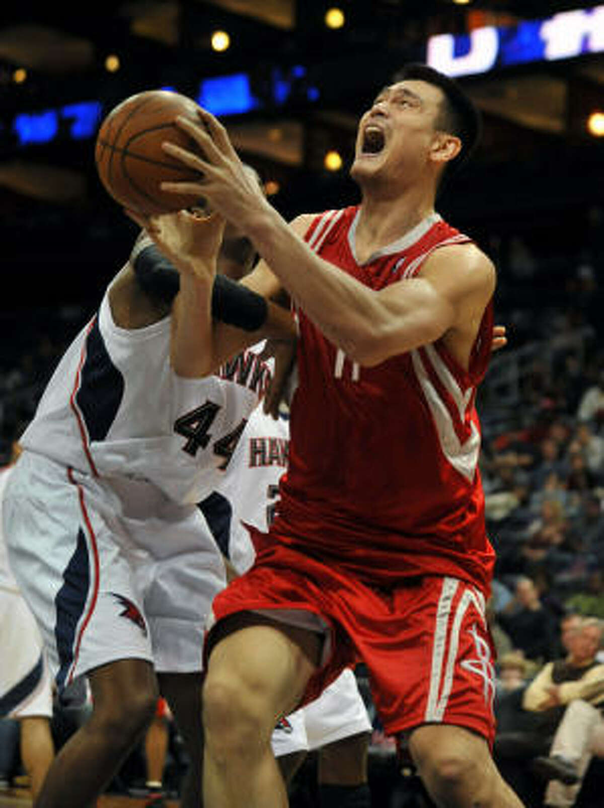Yao Ming, right, gets fouled by Hawks forward Solomon Jones on a shot attempt in the first quarter.