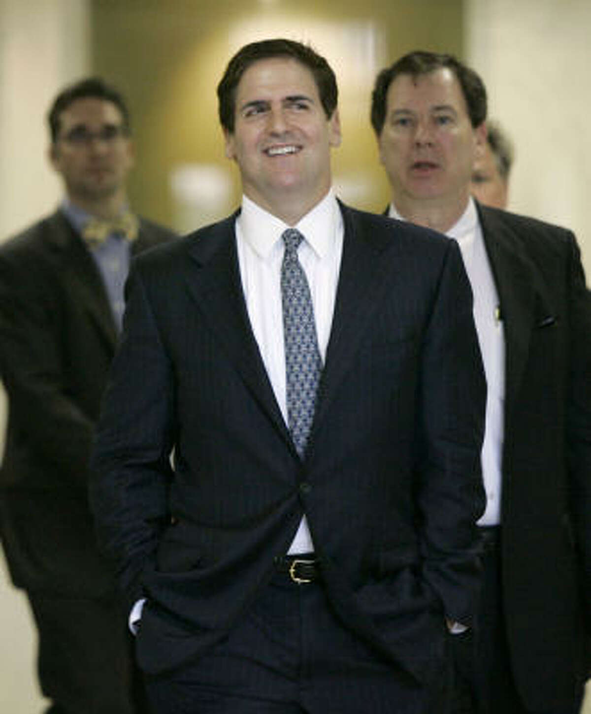 Mavericks owner Mark Cuban walks out of his federal hearing accompanied by members of his legal team May 26.