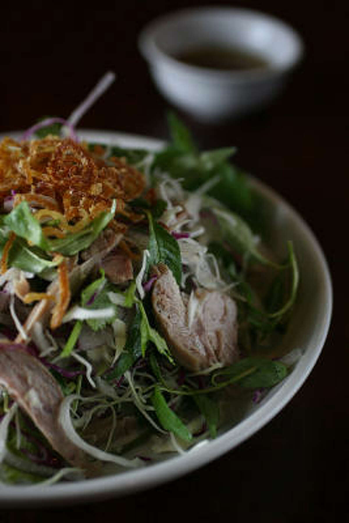In goi vit, Lime, pepper, sugar, ginger and fish sauce made a garlicky dressing to splash over a shredded duck salad laced with slivered red onion and freshened with leaves of cilantro and rau.