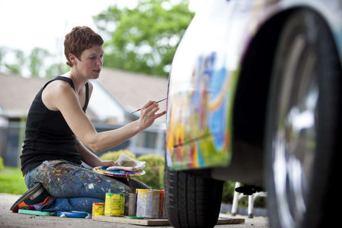 Robynn Sanders paints Psychedelic Surfer Dude, a restored 1963 Porsche 356 owned by David Duthu, in preparation for the 2009 Houston Art Car Parade.