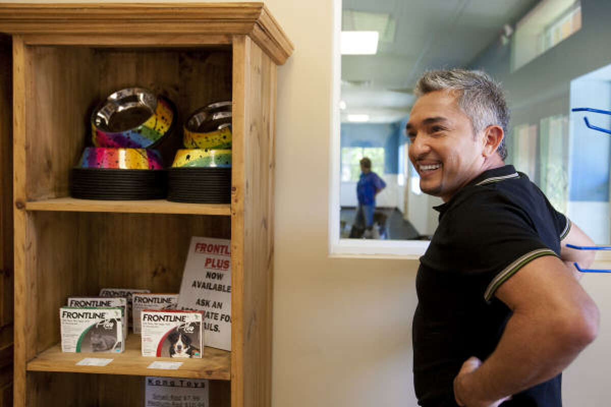 Cesar Millan shares a laugh with his production crew at Bed Bath & Biscuit pet care facility in Conroe. Millan is in the Conroe area filming segments for his hit National Geographic Channel television show, The Dog Whisperer.