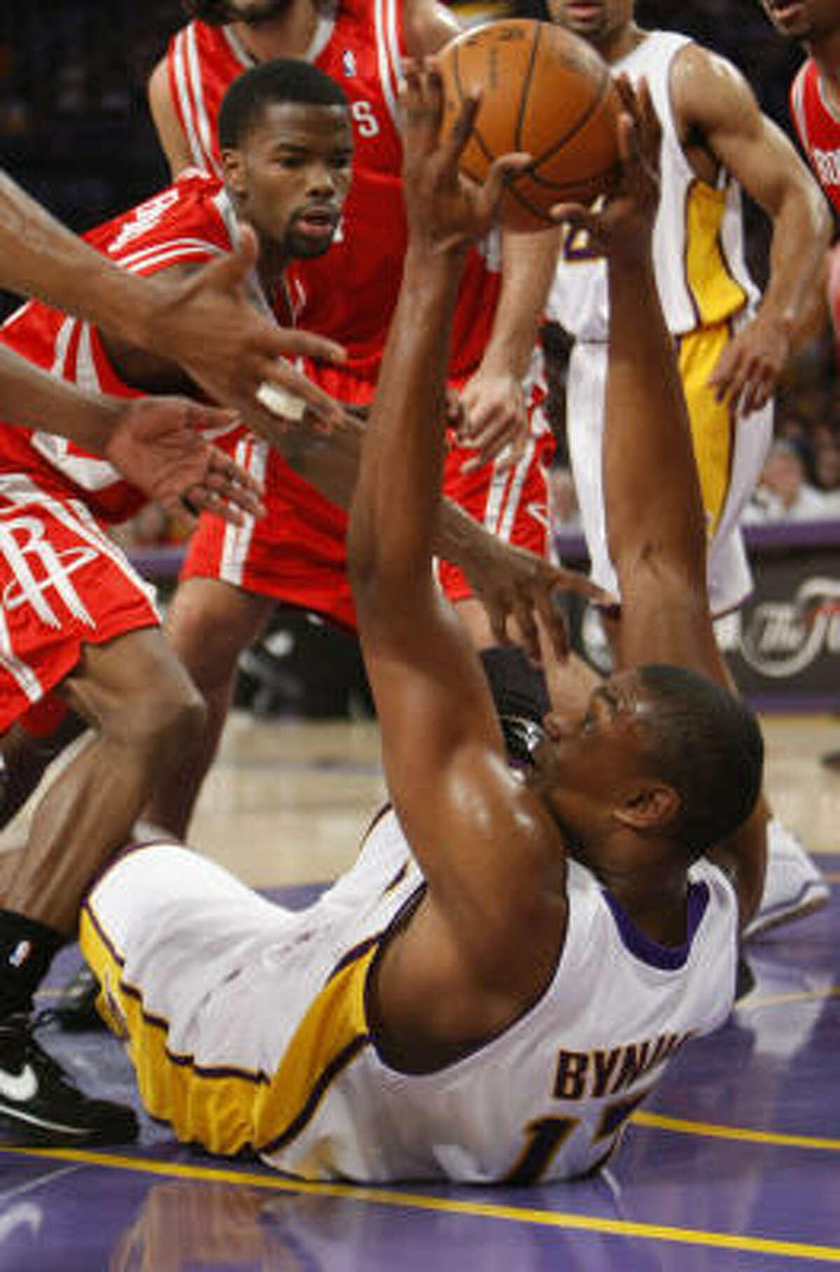 Aaron Brooks, left, looks to steal the ball from Lakers center Andrew Bynum during the first quarter.