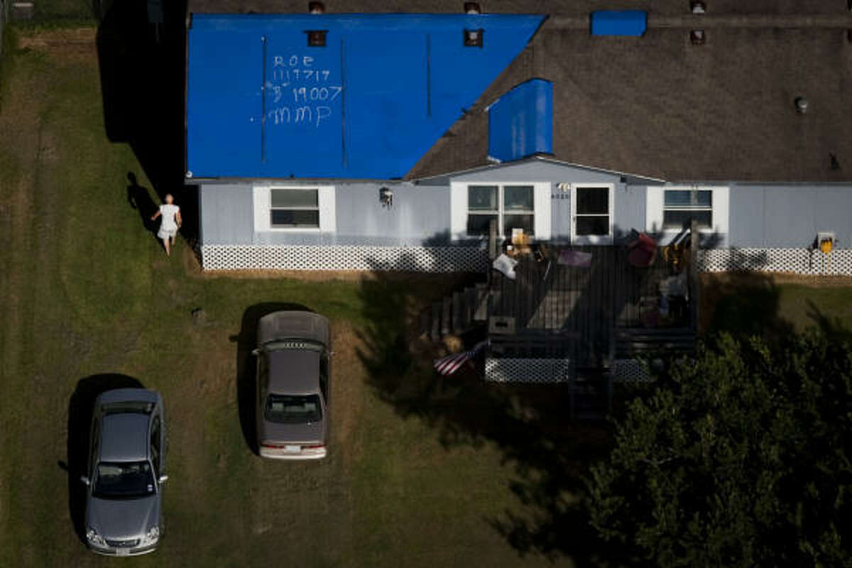 A storm-damaged house near Santa Fe still has a blue tarp on its roof nearly a year after Hurricane Ike.