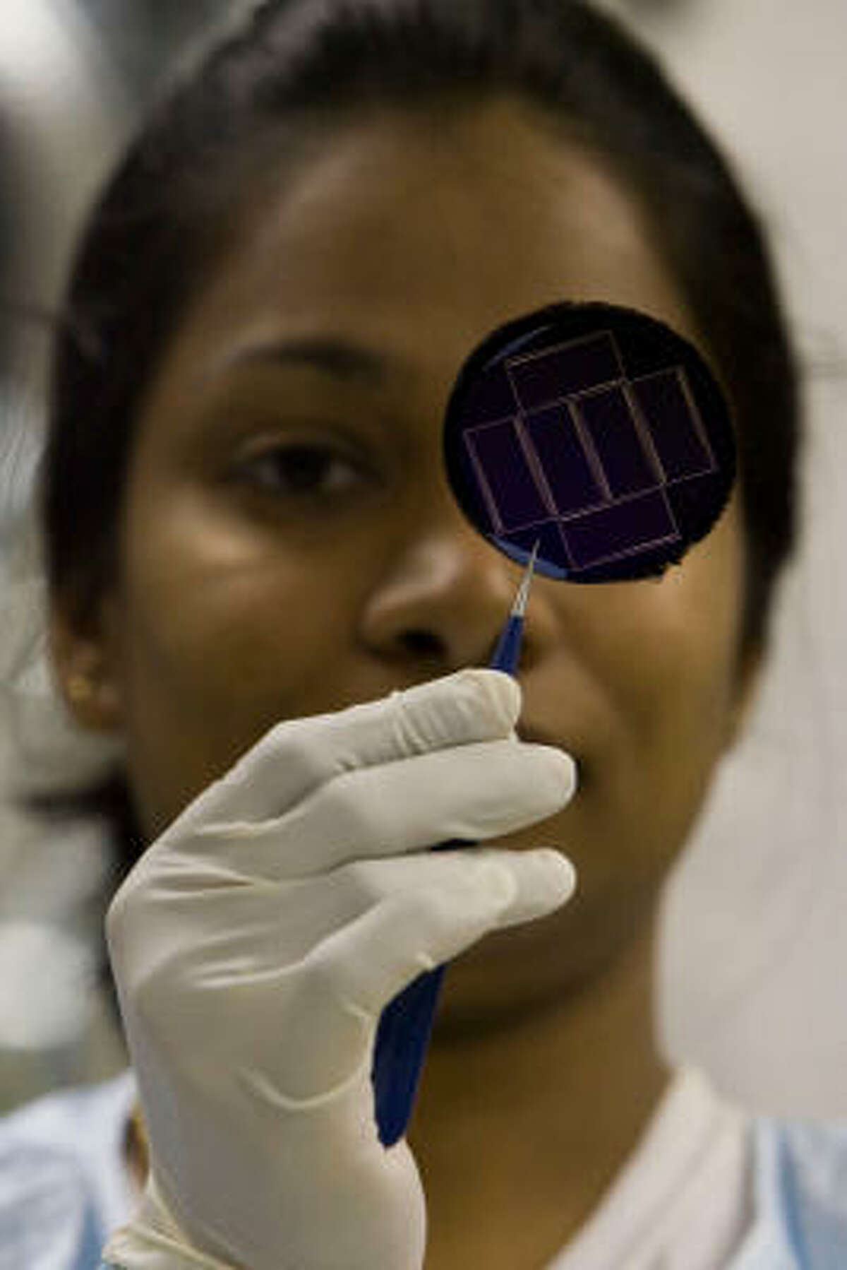 University of Houston doctoral student Chandani Rajapaksha examines a solar cell created at the University of Houston’s Center for Advanced Materials.