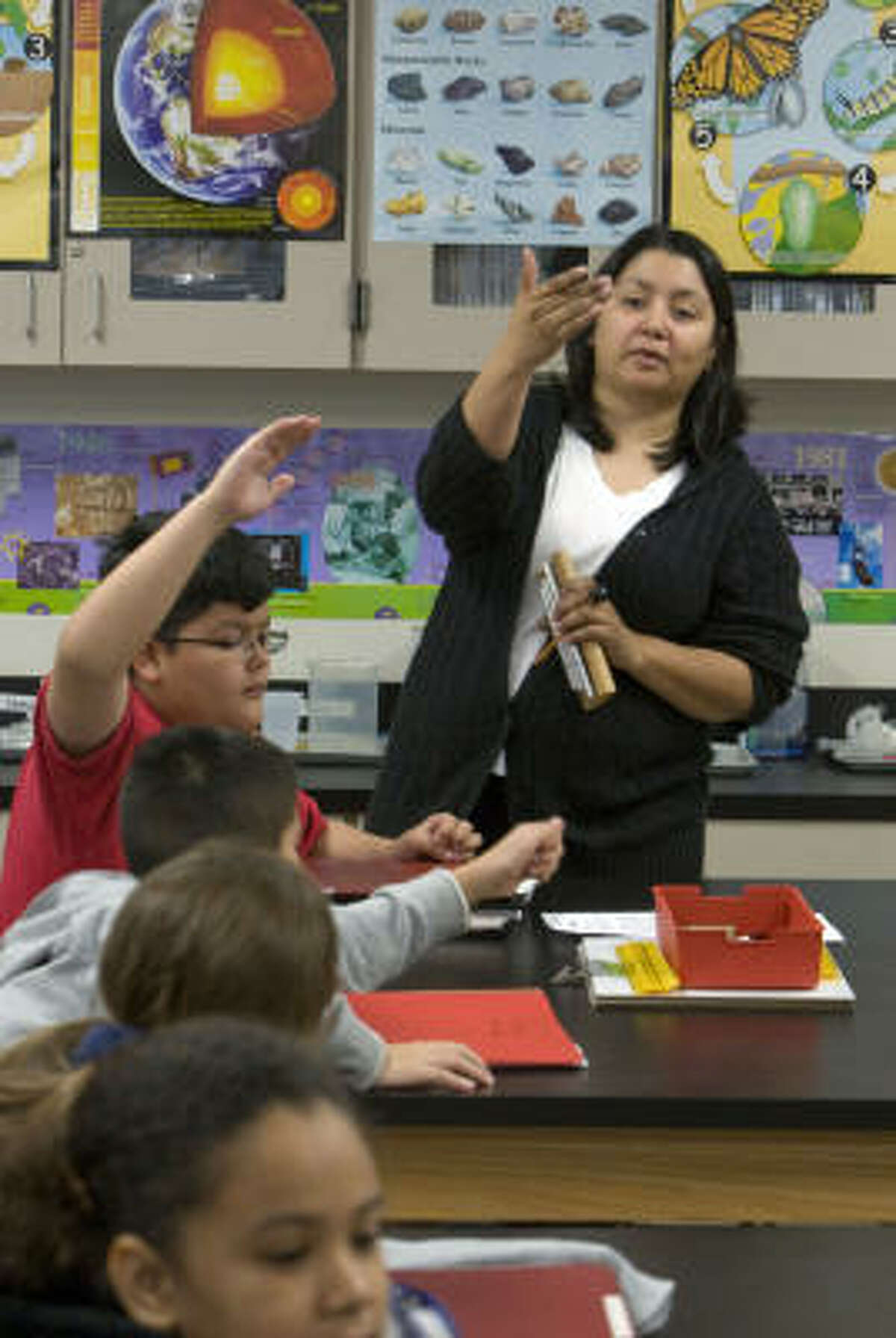 Teacher Norma Martinez leads students through a science lab at HISD’s Cornelius Elementary last month. The fifth-graders were studying how blubber interacts with water of different temperatures. The magnet school has a lab teacher for each grade.﻿