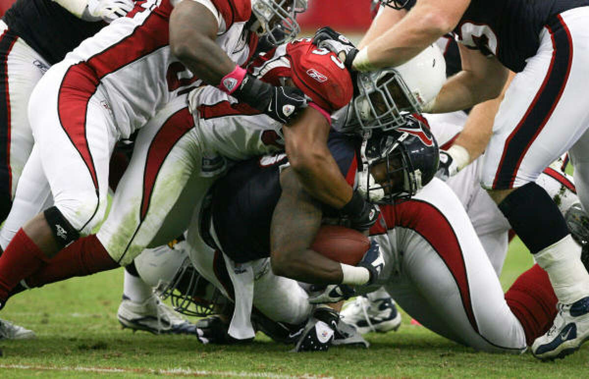 Texans running back Steve Slaton (20) is swarmed over by Cardinals defenders for a loss in the third quarter Sunday. Slaton had 39 yards on 13 carries. a 3-yard average, as the Texans continued a season-long trend of struggling on the ground.