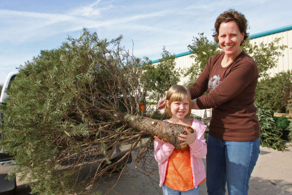 Gia Vandever of Sugar Land and her daughter, Nina, 6, recycle their Christmas tree at Eldridge Park in Sugar Land in 2008.