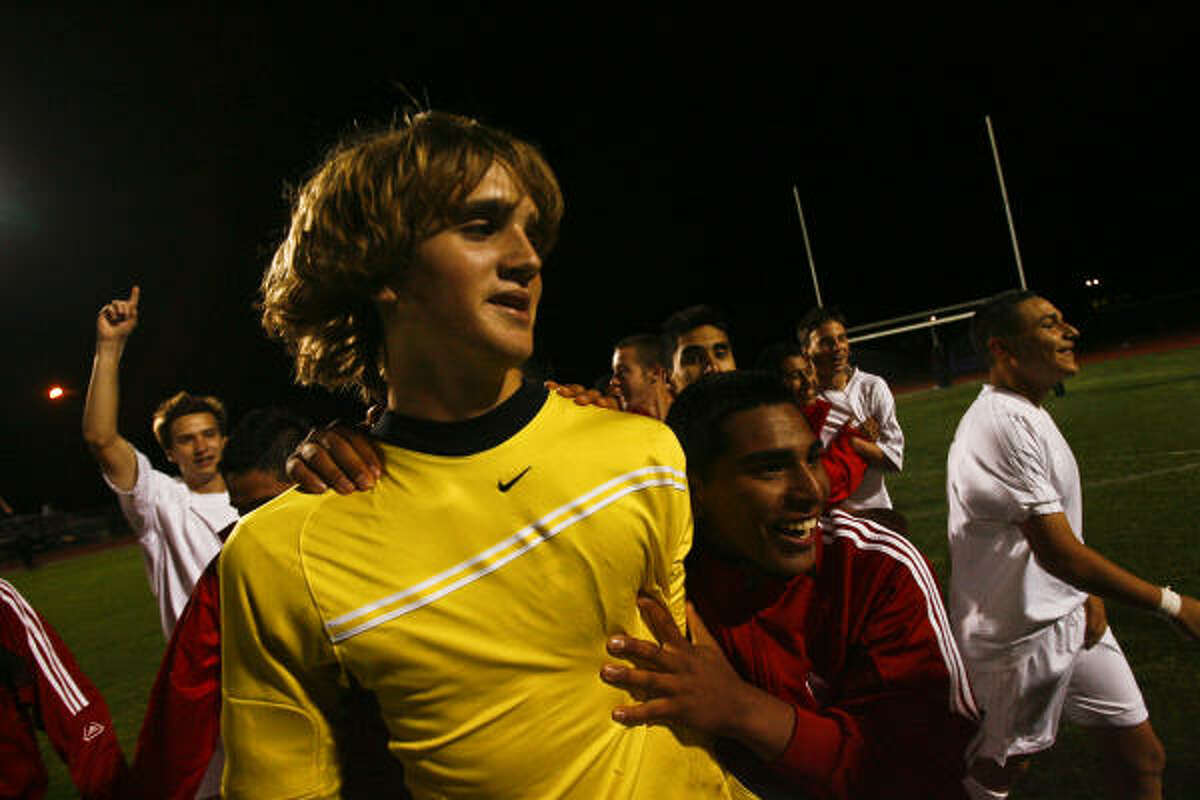 Katy High School soccer goalkeeper John Huttenhoff is congratulated by teammates after leading his team to a victory against Elsik. Huttenhoff played despite being ill before the game.