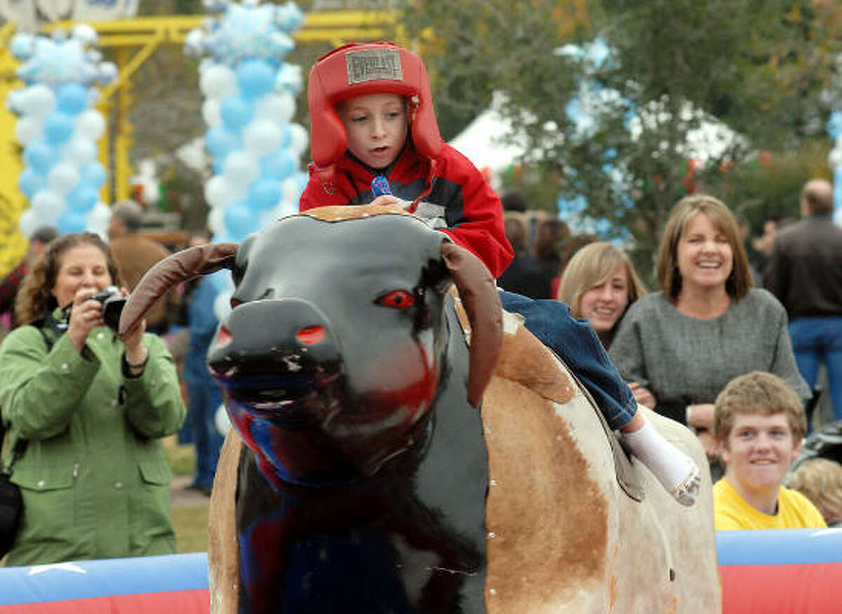 David Lewis,7, rides the mechanical bull at the Lanier Law Firm's Holiday Bash.