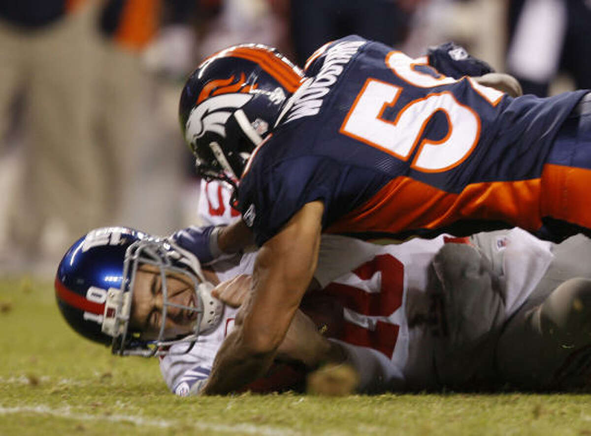 New York Giants quarterback Eli Manning is sacked by Denver Broncos linebacker Wesley Woodyard.