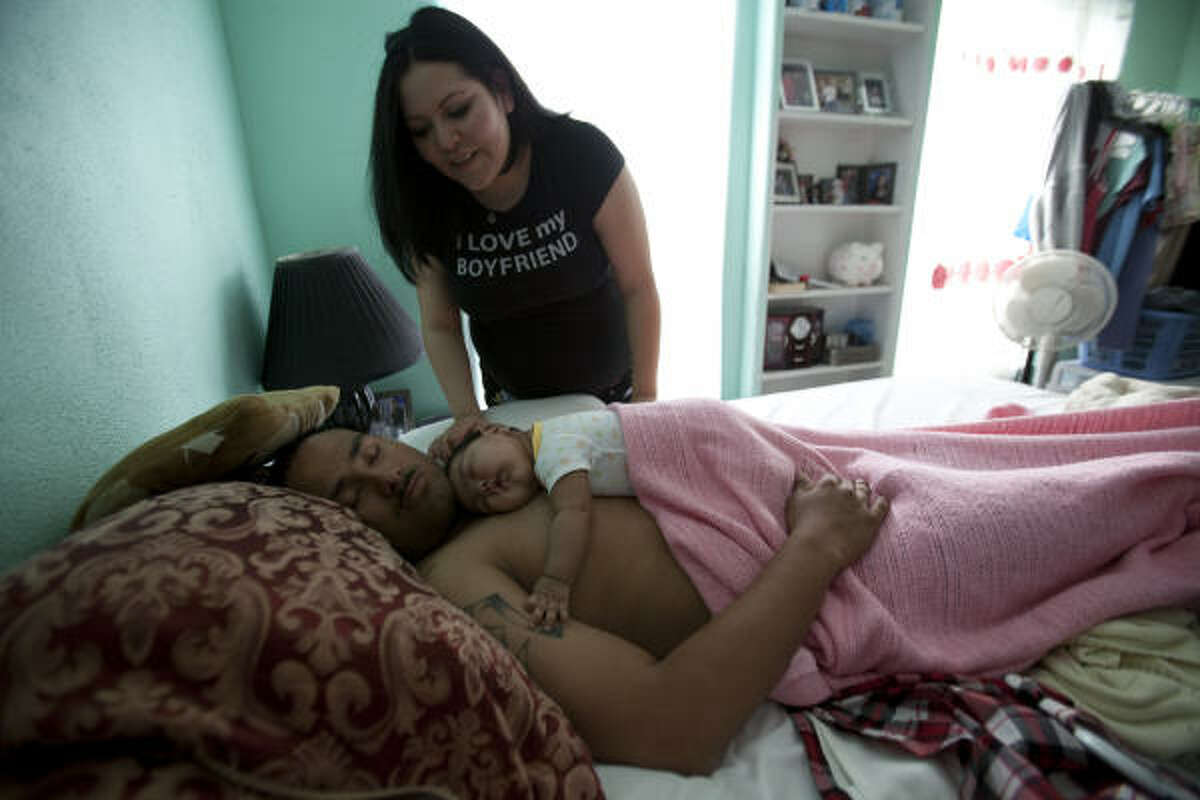 Laura Patricia Gonzalez tries to wake up her future husband Spc. Antonio Hernandez, who is sleeping with their three-month-old daughter, Karen Alicia Hernandez, on their wedding day. Spc. Hernandez will be deploying with Texas National Guard's 72nd Infantry Brigade Combat Team. They are preparing for a year-long deployment, including nine months in Iraq.