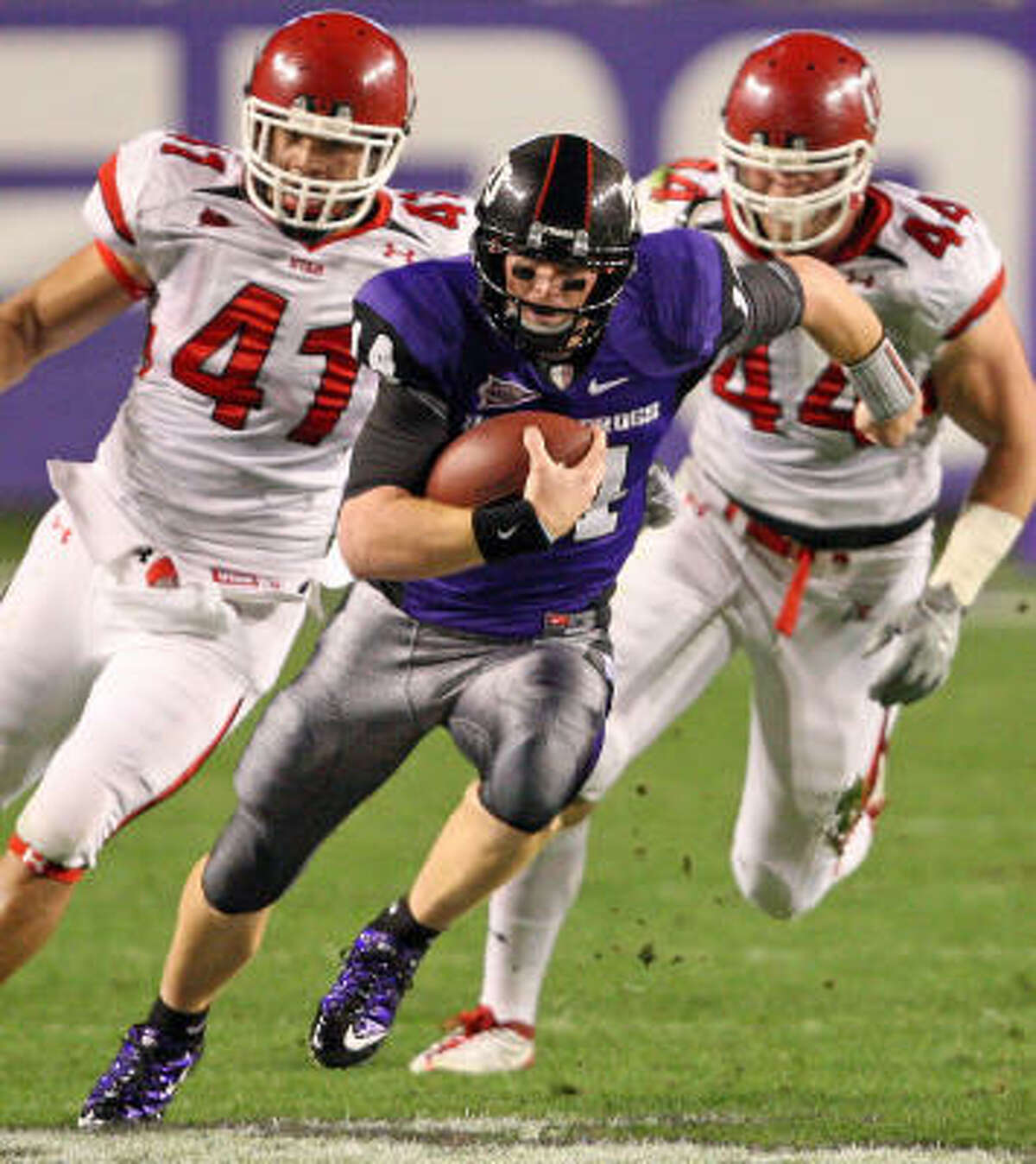 Texas Christian quarterback Andy Dalton (14) out runs Utah defenders Koa Misi (41) and Dave Kruger (44) in the first half of play at Amon G. Carter Stadium on Saturday.