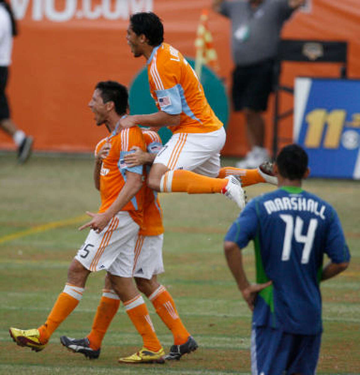 Houston Dynamo forward Brian Ching, left, celebrates his goal in the 96th minute.