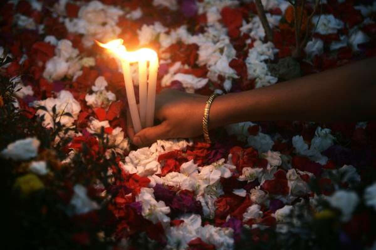 A Christian woman lights candles on the tomb of her relatives on All Souls' Day, in Calcutta, India.