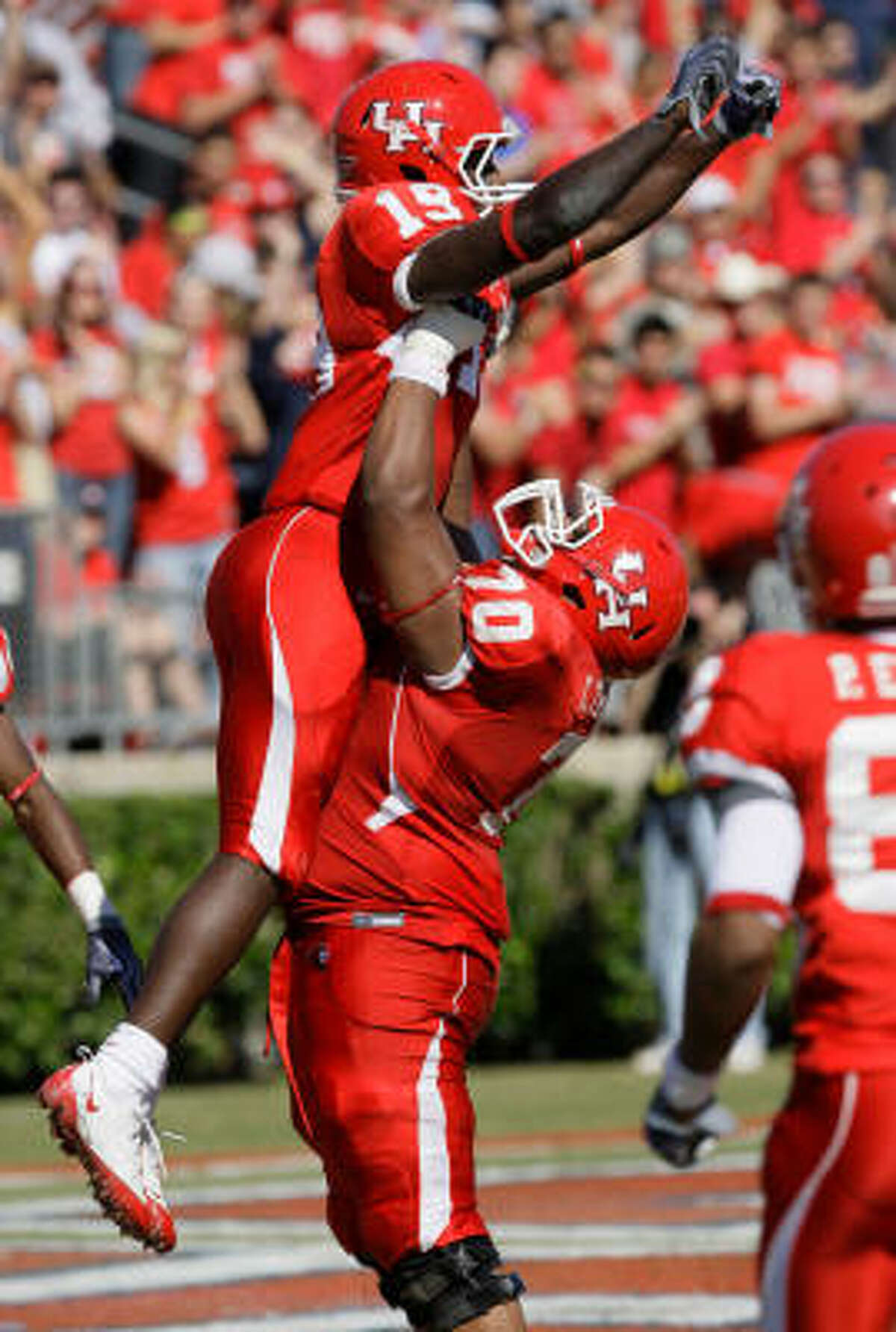 UH's James Cleveland (19) celebrates his fourth-quarter touchdown with Chris Thompson.