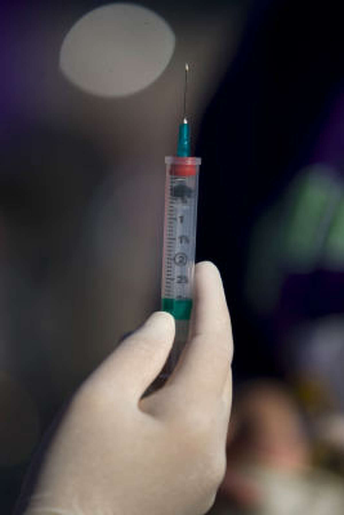 An H1N1 vaccine is prepared by a nurse as hundreds took part in the Montgomery County Health Department's annual drive-through flu shot clinic at the Lone Star College parking lot Saturday, Oct. 24, 2009