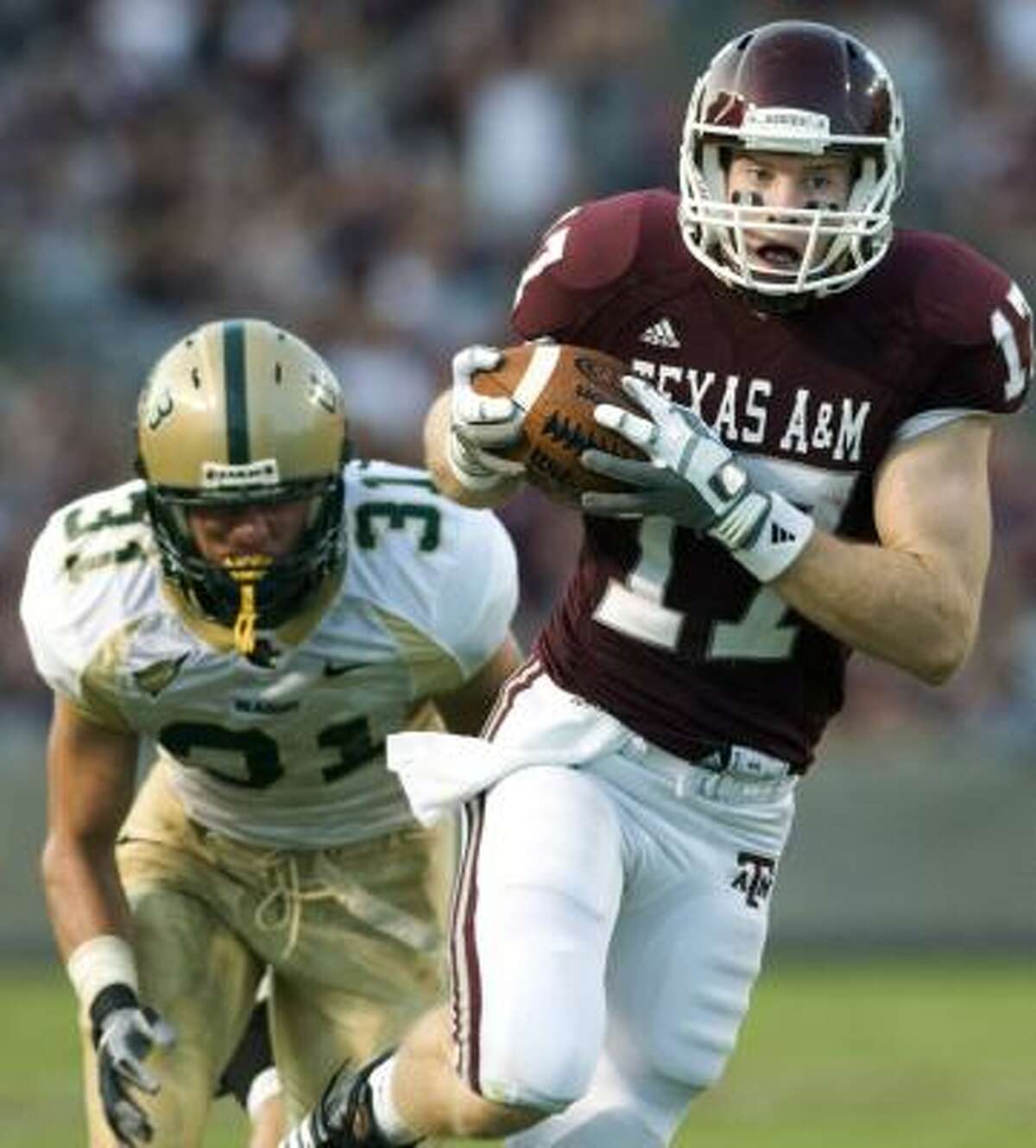 Texas A&M's Ryan Tannehill pulls in a catch for 58 yards past UAB's Chase Daniel during the second quarter Saturday.