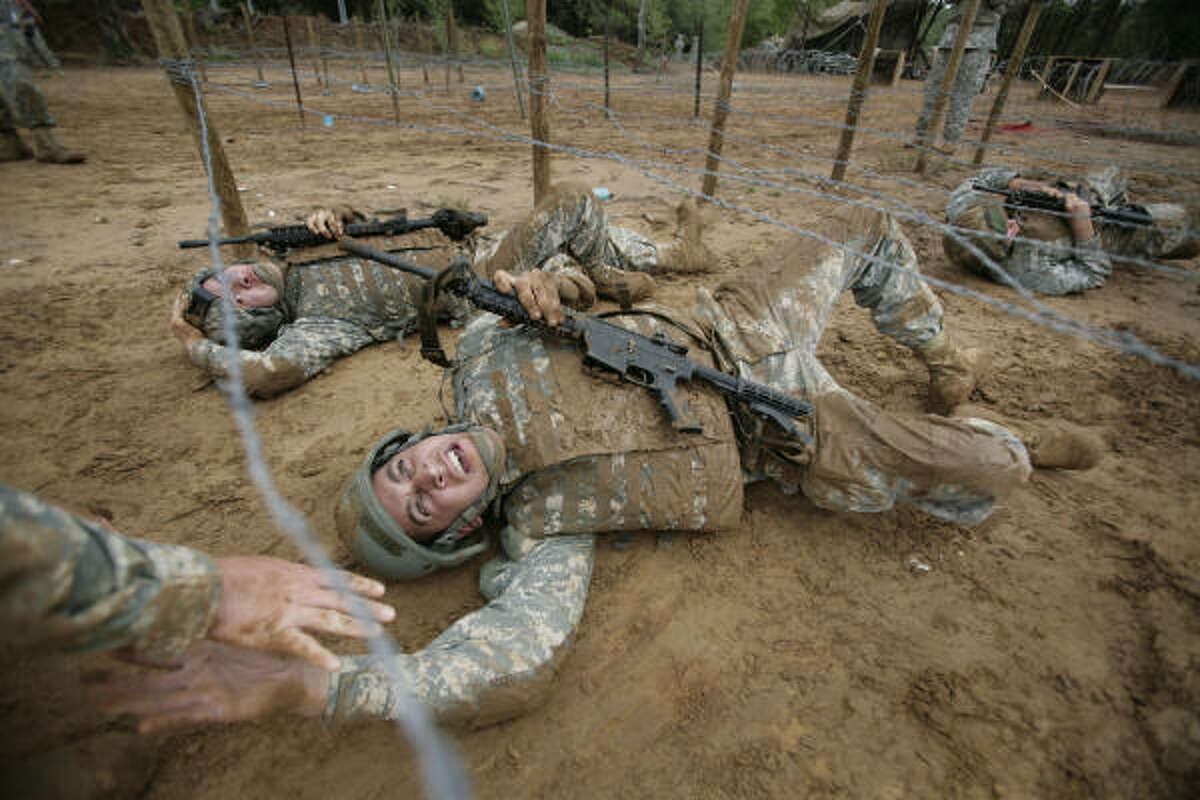 SGT Josh Matthew Whitmore reaches out to a battle buddy while crawling on his back during tactical lane training where soldiers complete first and second installments of Pre-Mobilization Training at Camp Swift as the 72nd Infantry Brigade Combat Team prepares for deployment to Iraq in the winter.